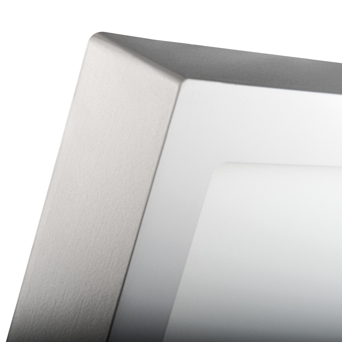 Close-up van een zilveren frame rond een wit, helder lichtpaneel. Het frame heeft een textuur.