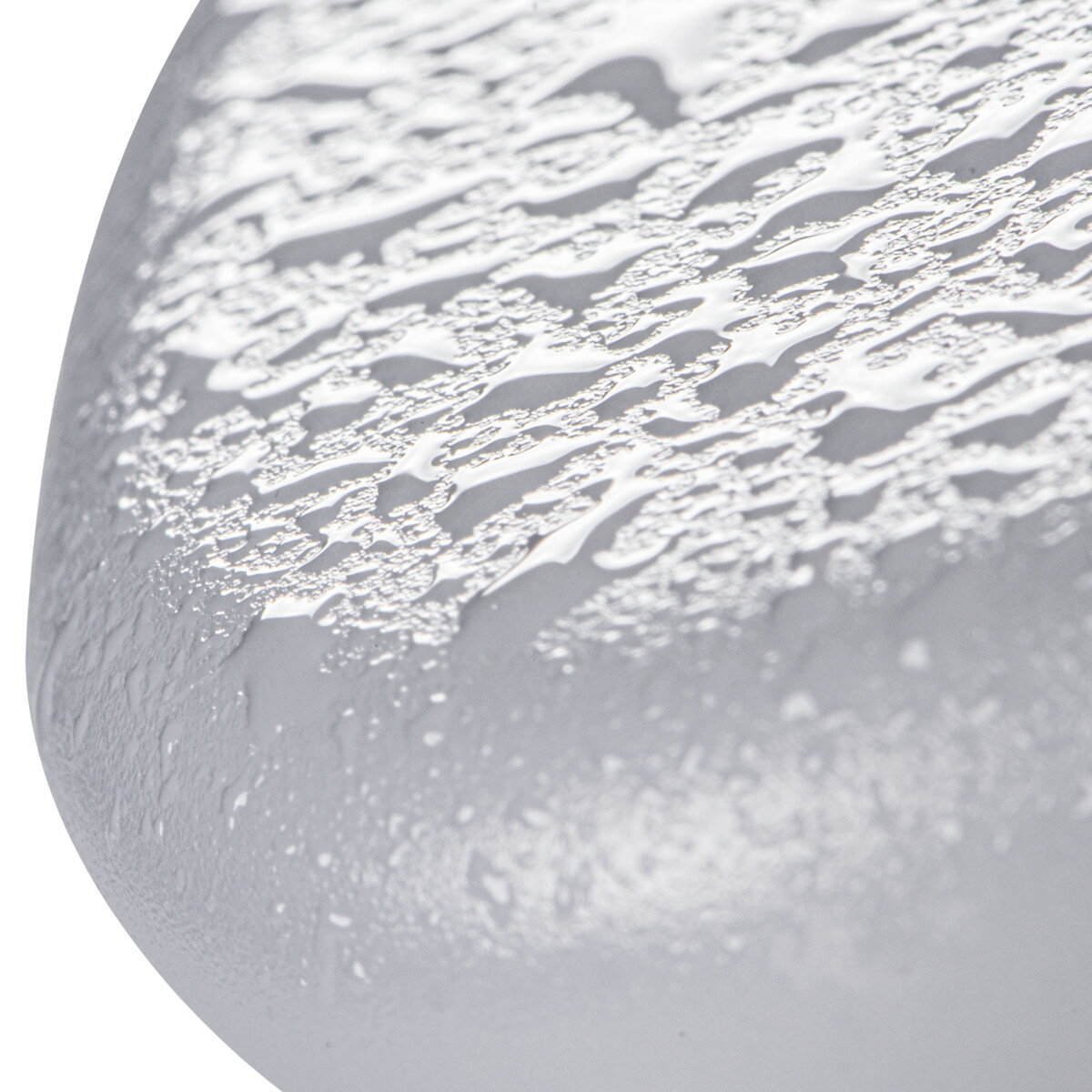 Gros plan d'une surface arrondie et mouillée. Des gouttelettes d'eau recouvrent la texture claire.