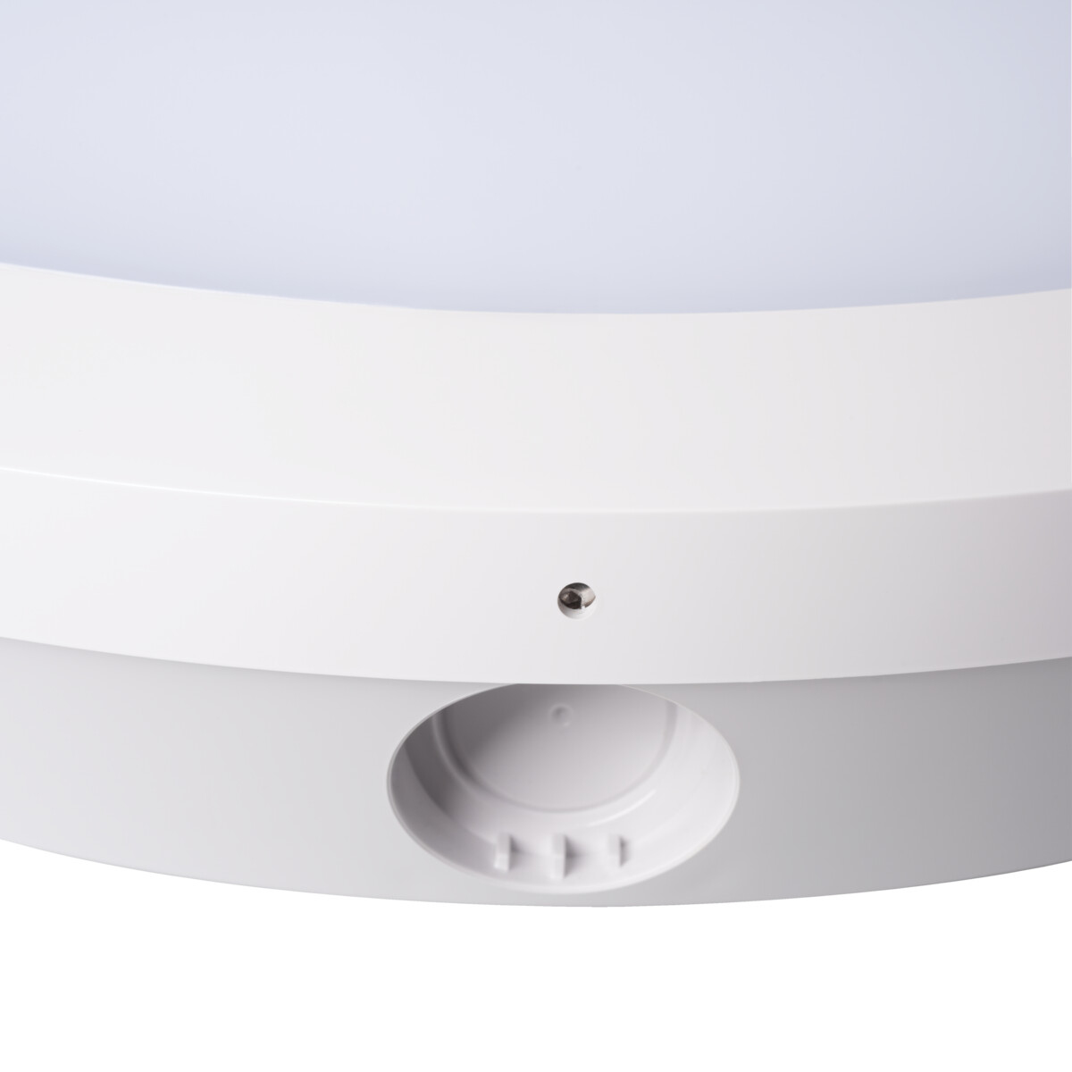 Primo piano di un apparecchio di illuminazione bianco. Ha una forma circolare con una sezione incassata e una piccola apertura.