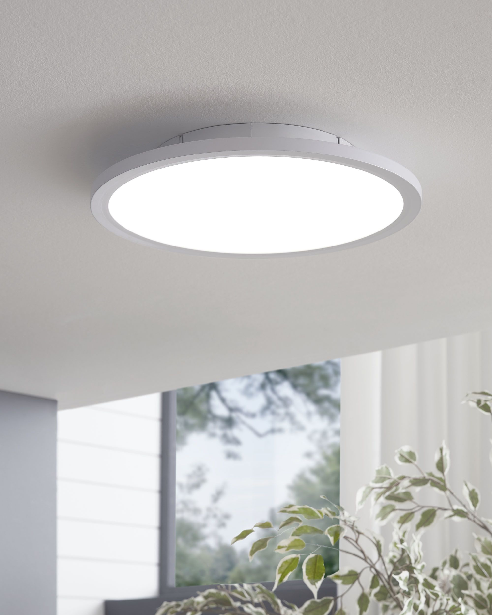 Lampada da soffitto rotonda, bianca con un centro luminoso e illuminato.