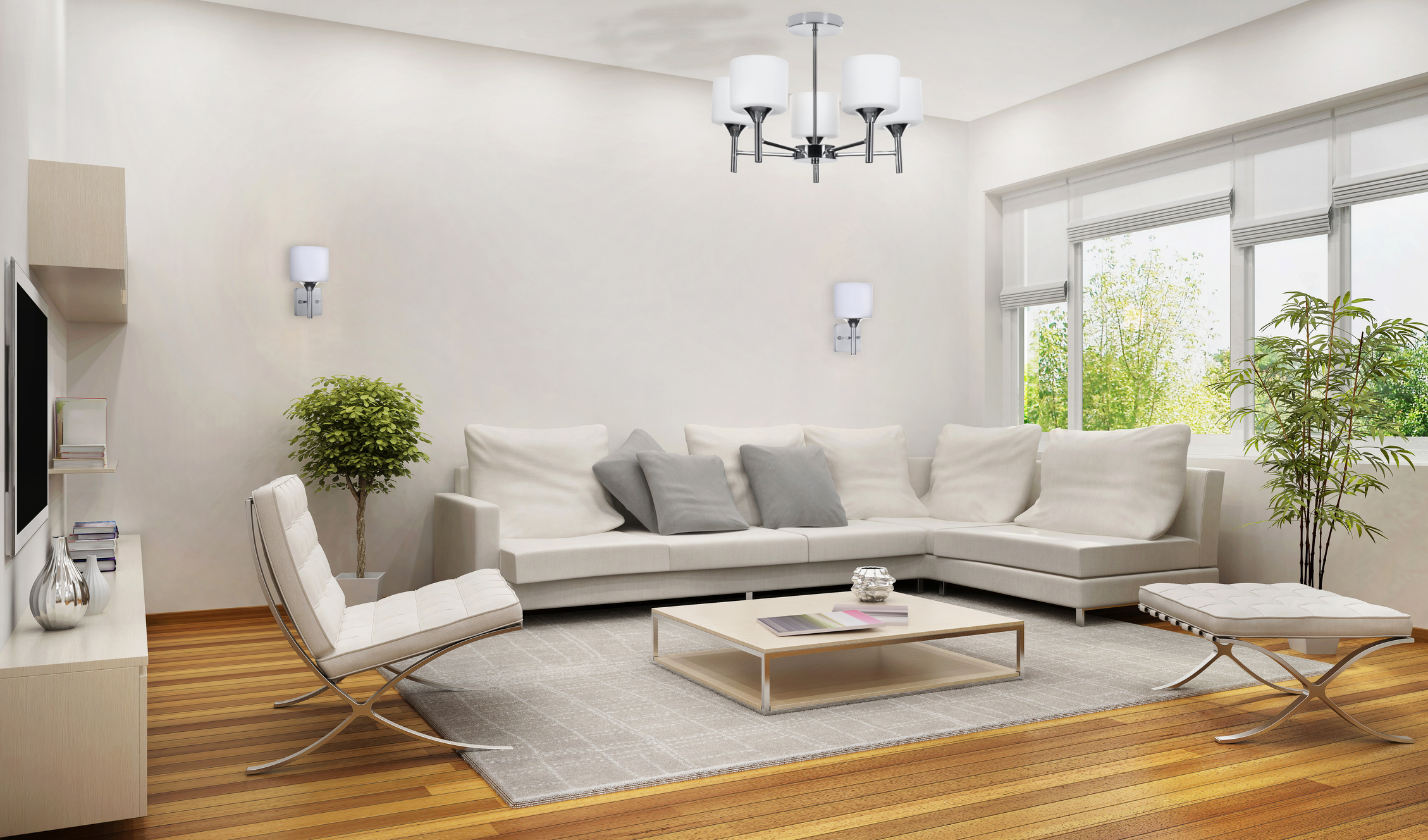 Wnętrze salonu z białymi meblami, żyrandolem i drewnianą podłogą. Widoczna jest roślina.