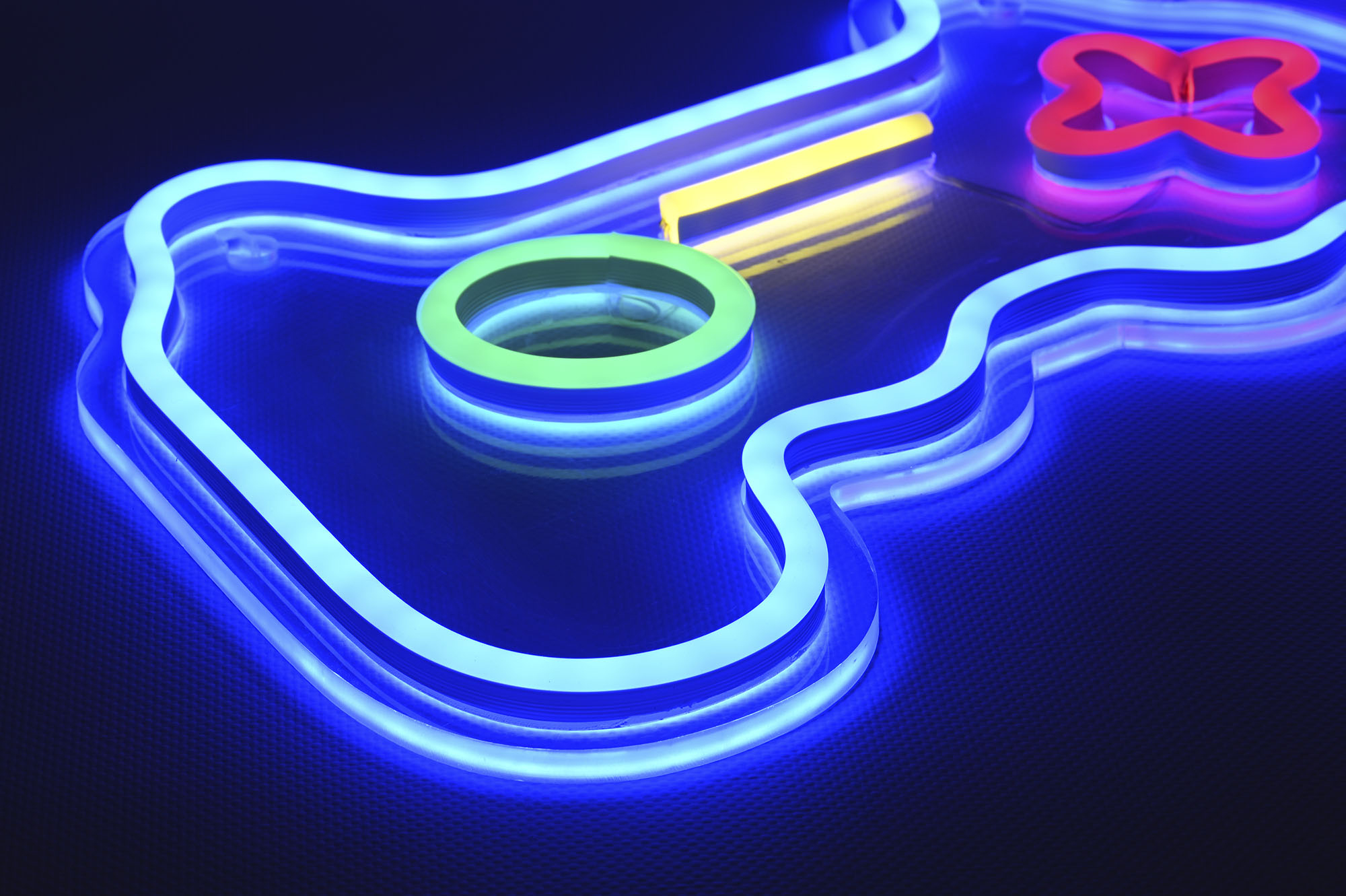 Eine Neon-Gamepad-Controller-Form mit blauem Umriss, roten Knöpfen und einem gelben Mittelbalken.