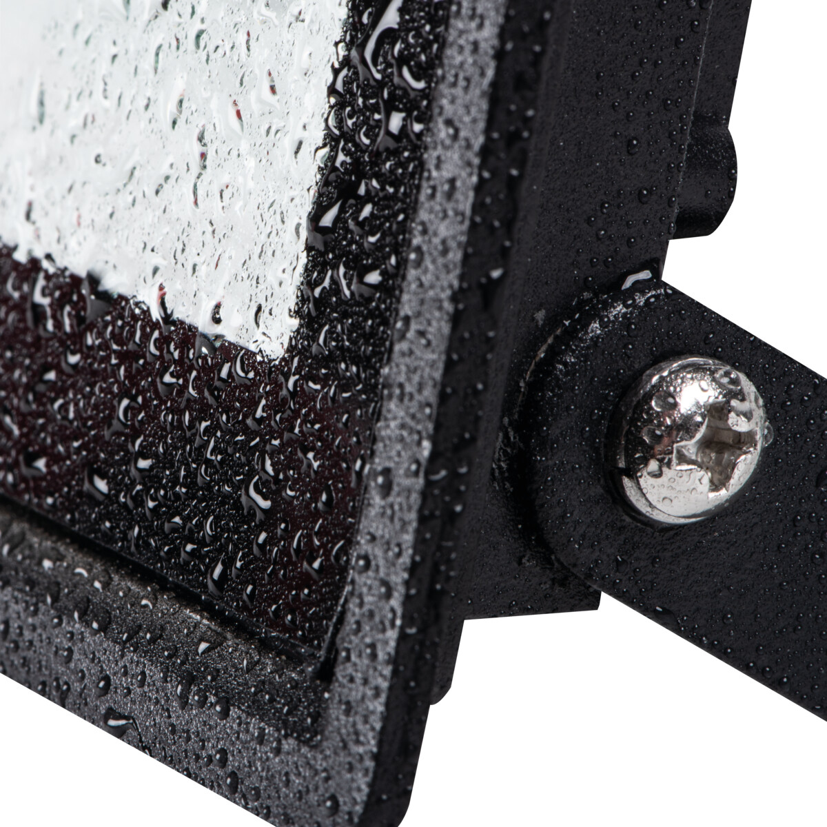 Close-up of a black flood light with water drops on the surface.