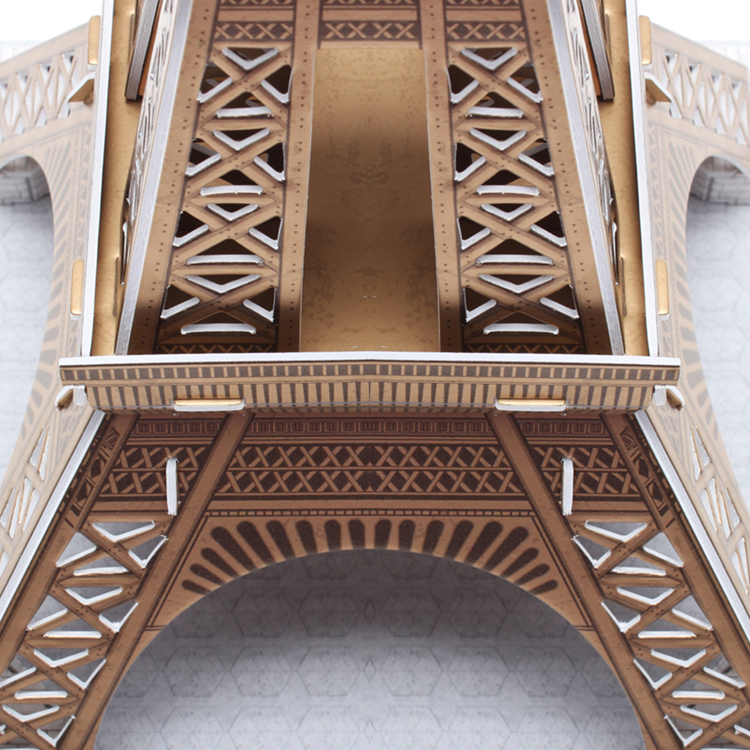 Un primo piano di un modello 3D della Torre Eiffel, che mostra i dettagli intricati della struttura, su una superficie bianca.