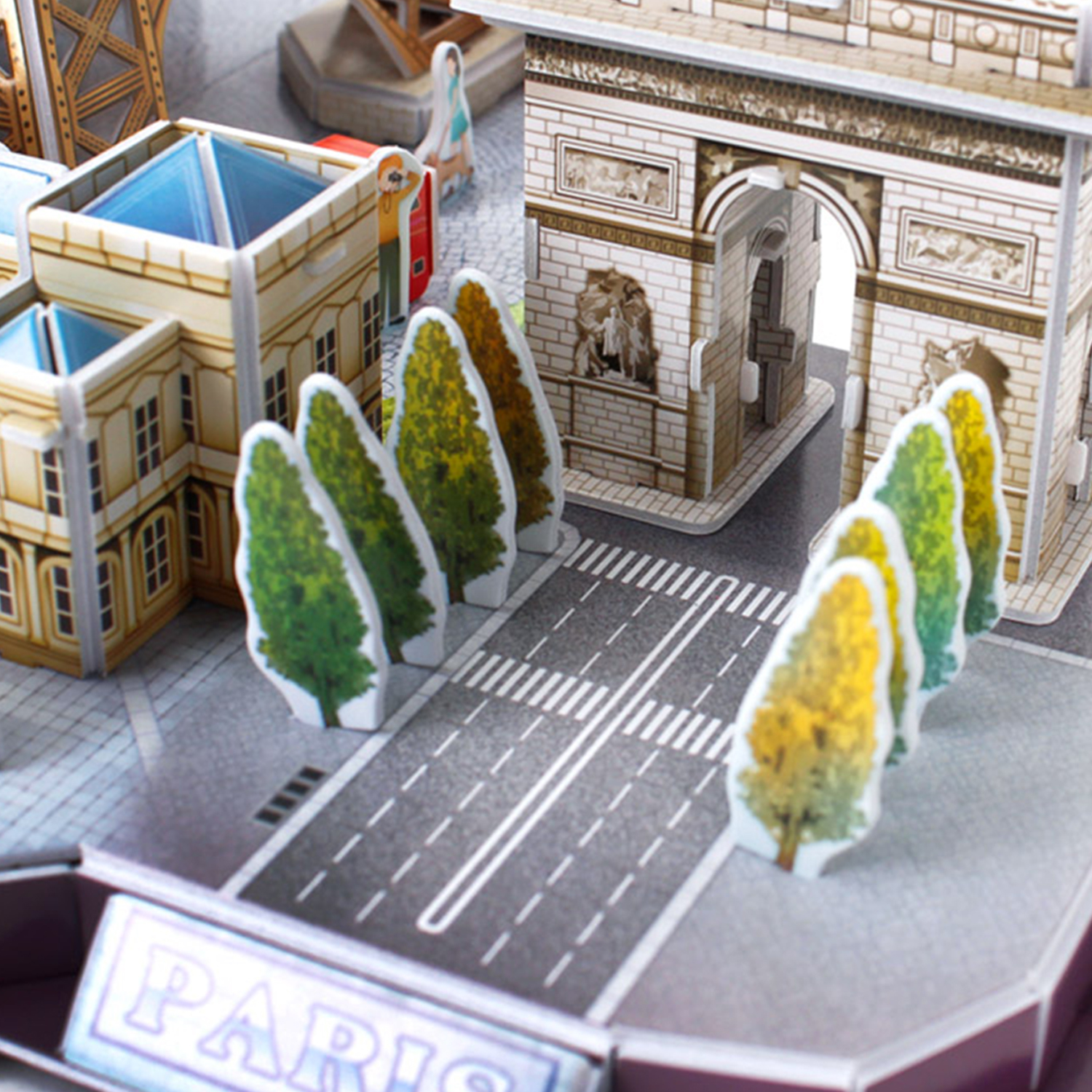 Puzzle 3D Paryża z Łukiem Triumfalnym, drzewami i modelami budynków na ulicy.
