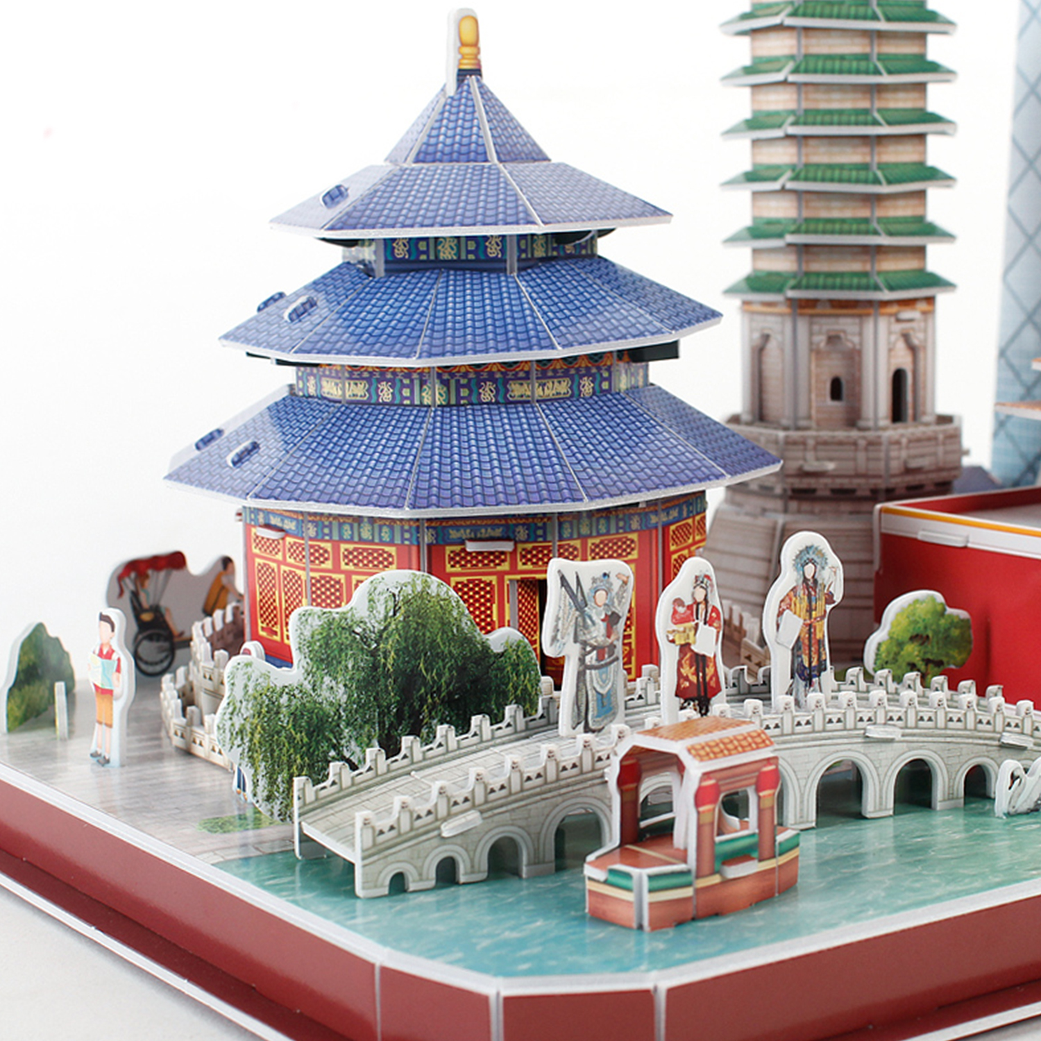 Modello di tempio cinese con figure, ponti e base rossa.