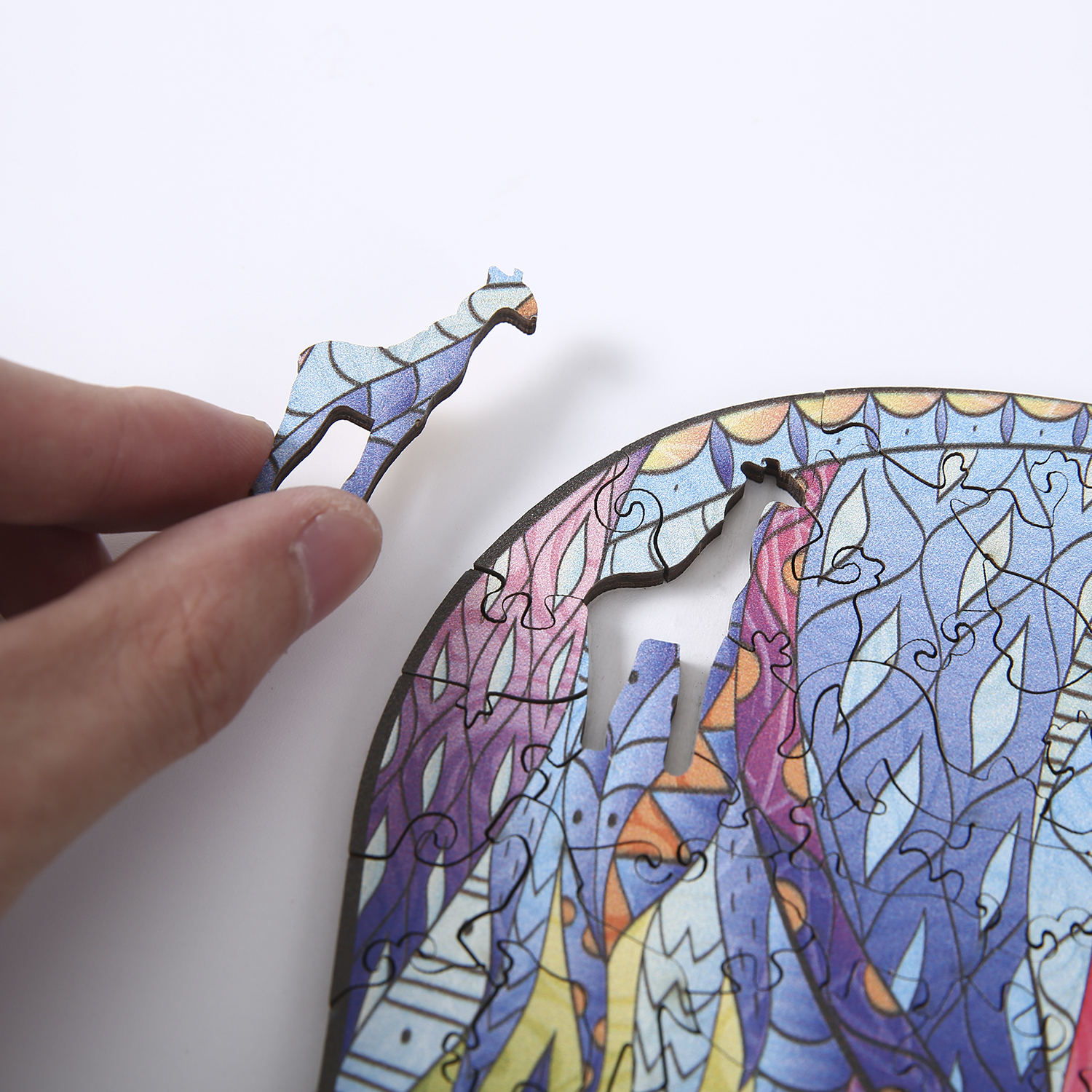 Eine Hand hält ein Puzzleteil über einem runden Puzzle. Es ist blau, lila und hat eine einzigartige Form.