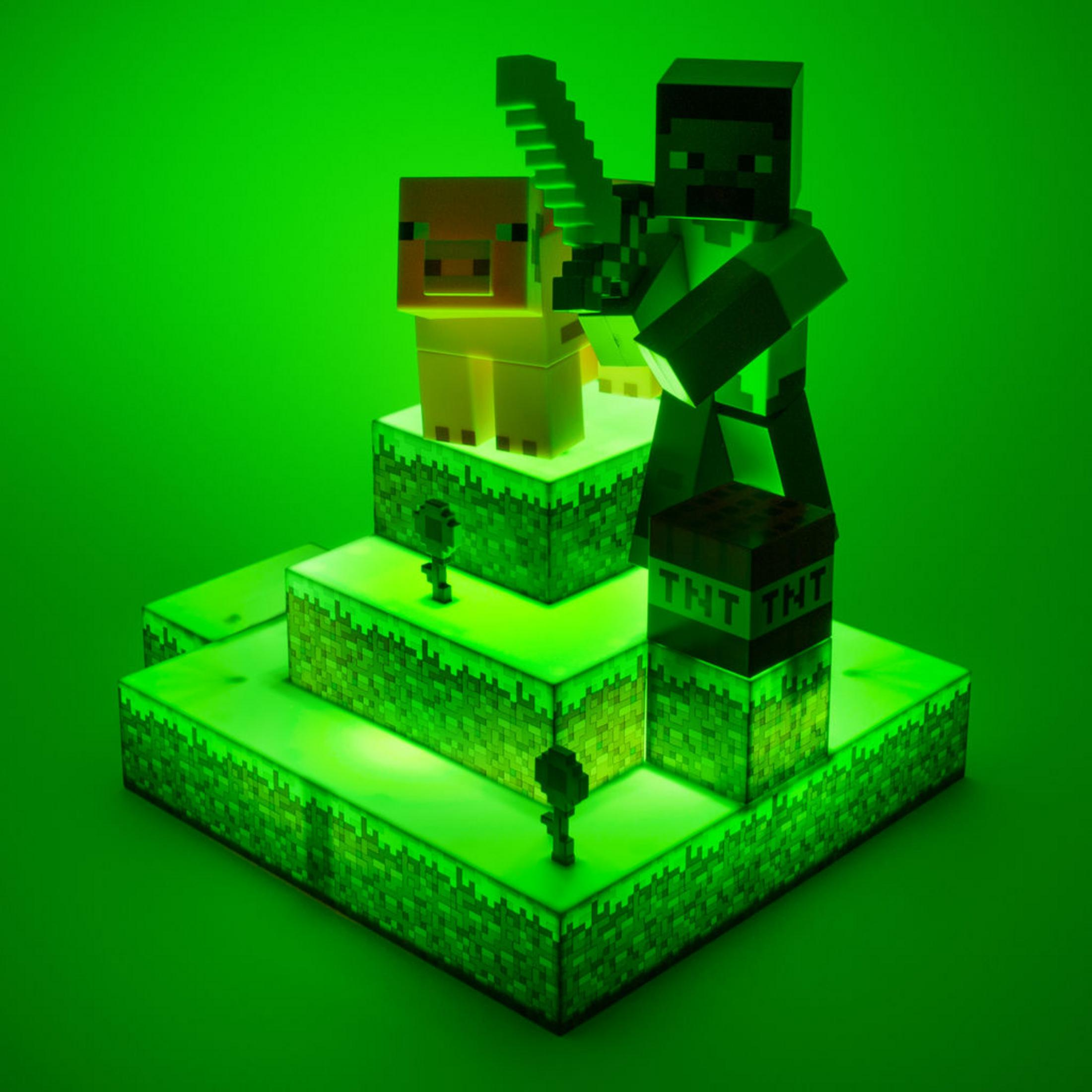 Diorama Minecraft z figurką trzymającą miecz, świnią, TNT i zieloną podstawą.