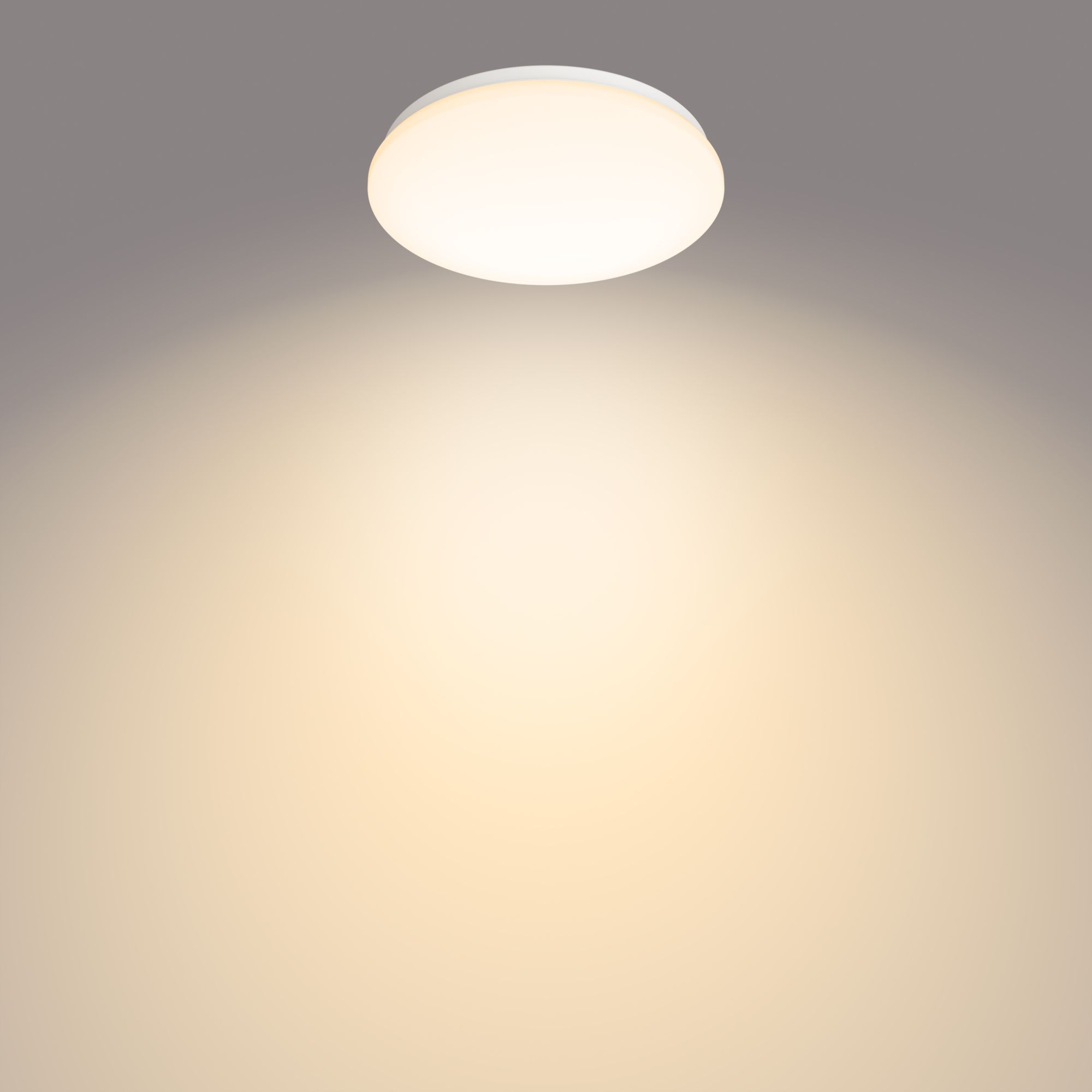 Ronde, witte LED plafondlamp die warm licht uitstraalt, tegen een grijs naar gele achtergrond.