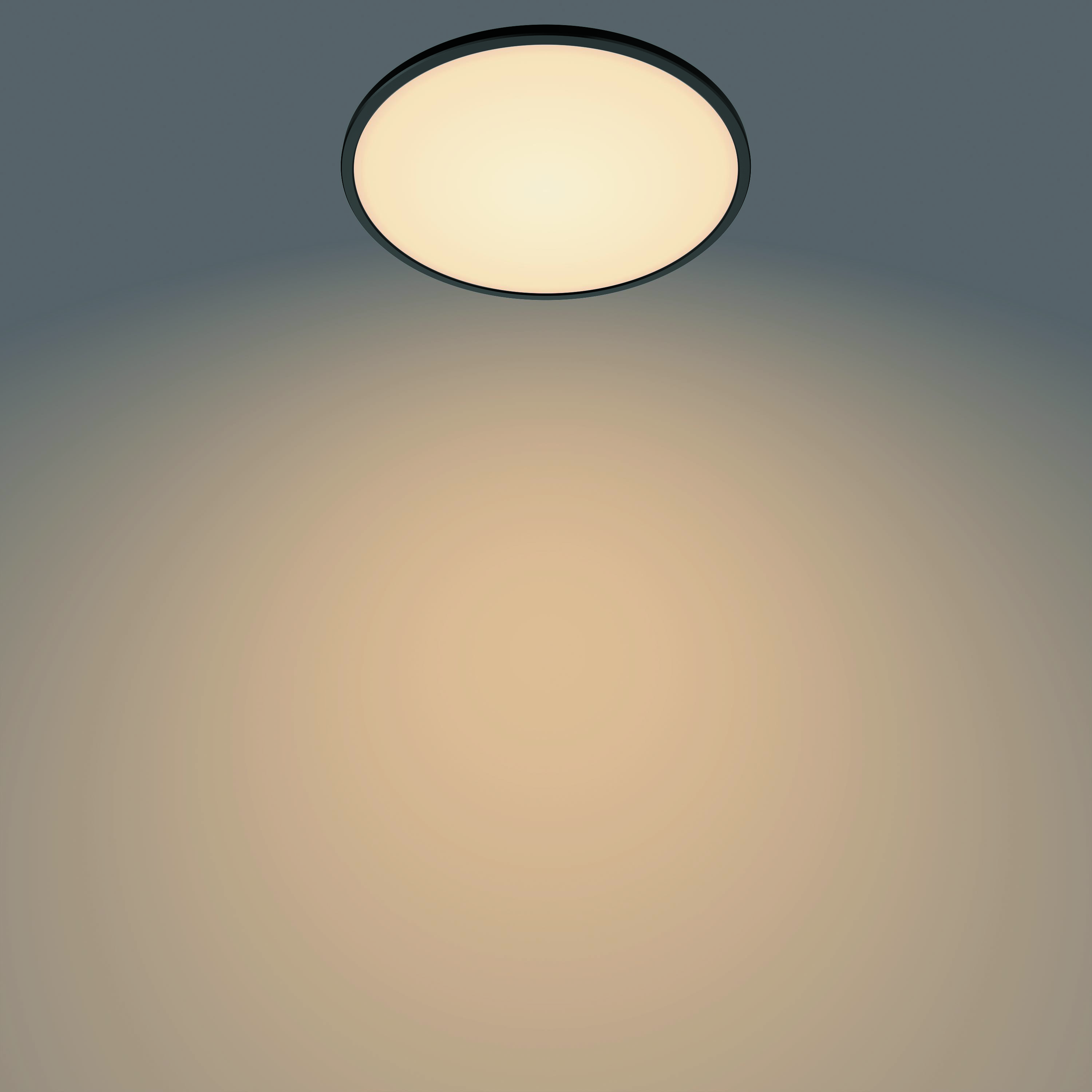 Plafonnier circulaire noir émettant une lumière blanc chaud. Sur fond neutre.