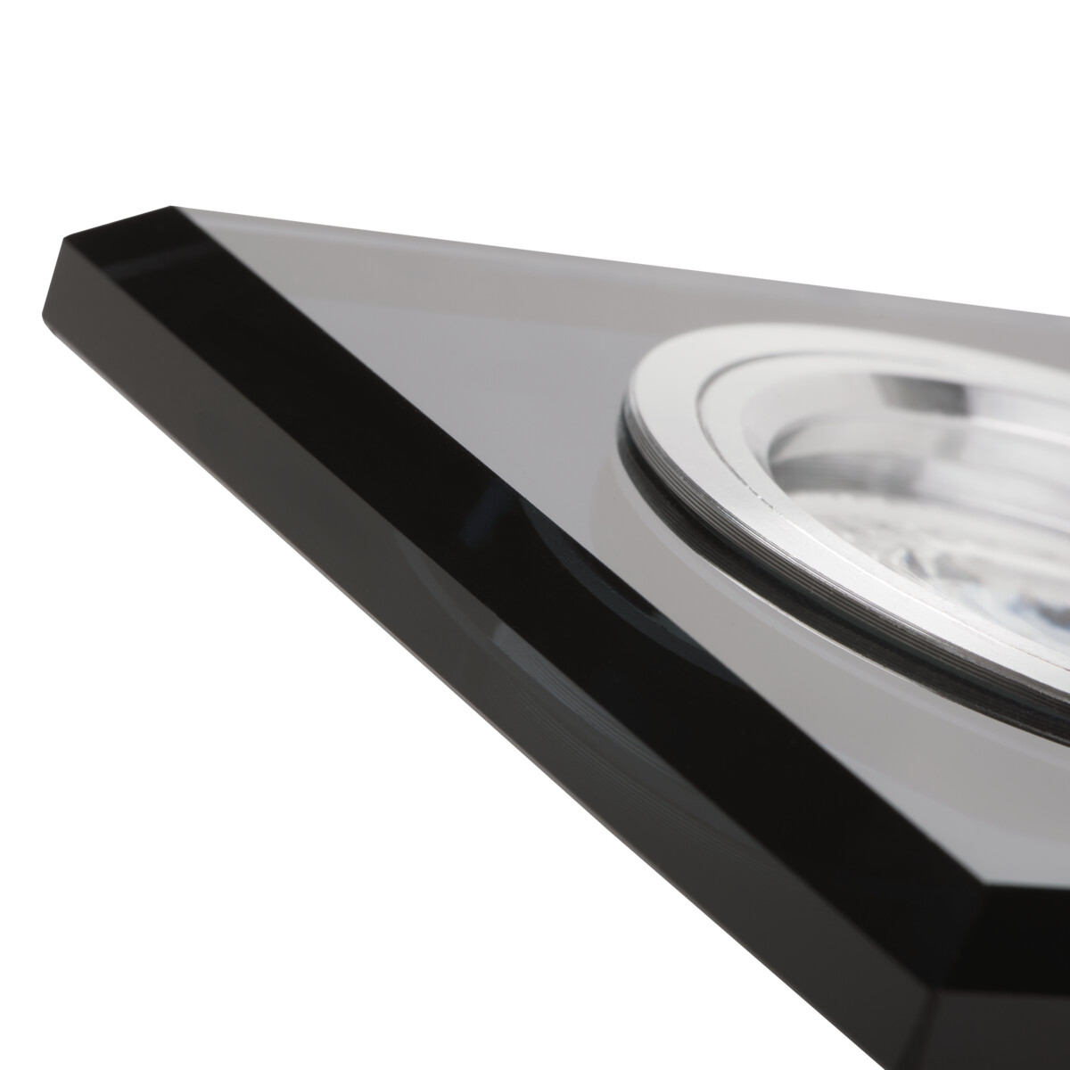 Close-up van een zwarte en zilveren armatuur met een glanzend reflecterend oppervlak.