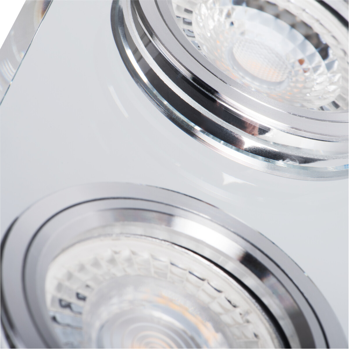 Close-up van een inbouwspot met twee zichtbare lichtbronnen, chromen accenten.