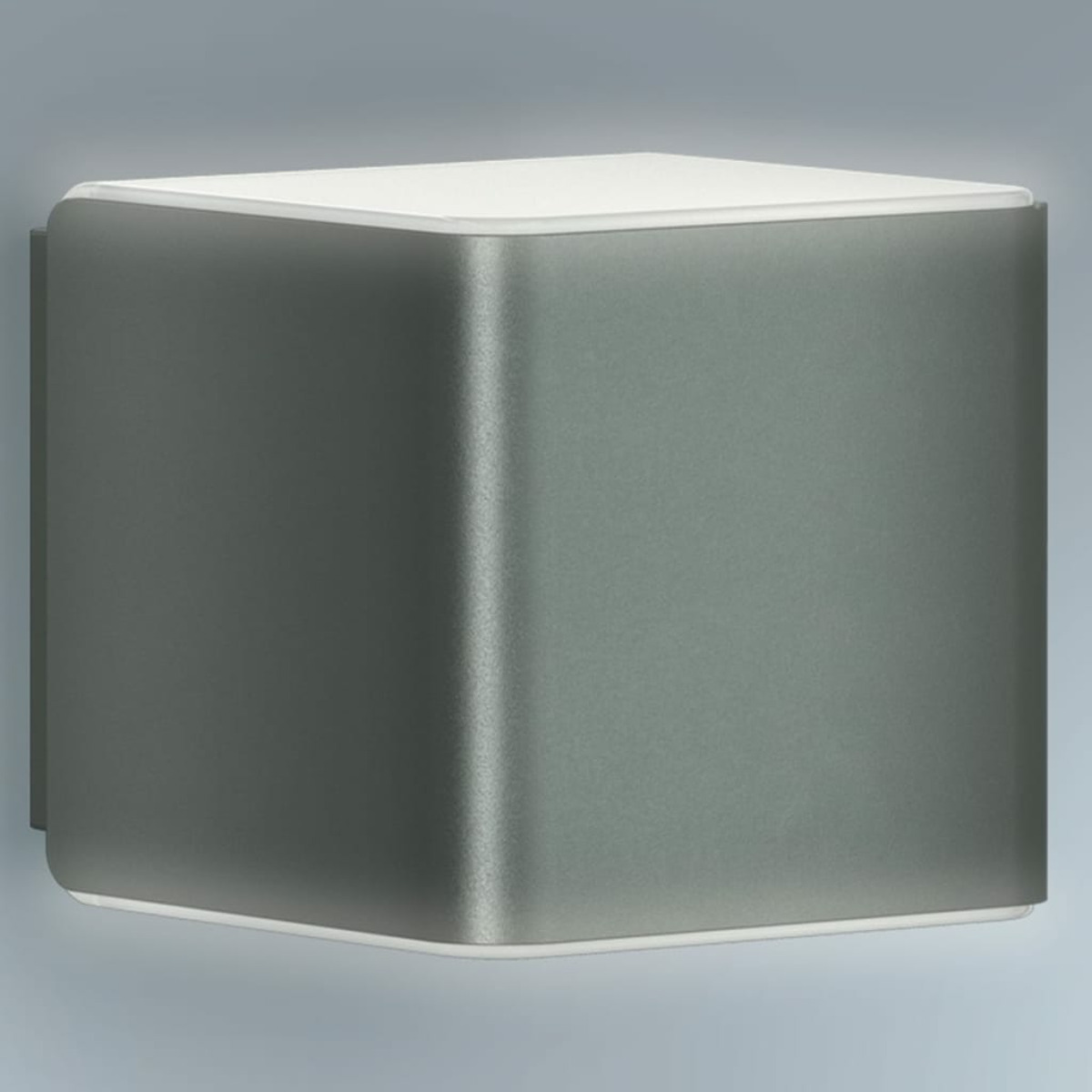 Lampada da parete grigia a forma di cubo con parte superiore bianca, su sfondo grigio chiaro. Bordi arrotondati.