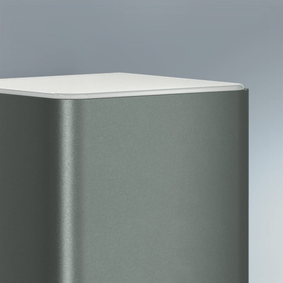Oggetto a forma di cubo grigio metallizzato con parte superiore bianca, su sfondo sfumato.