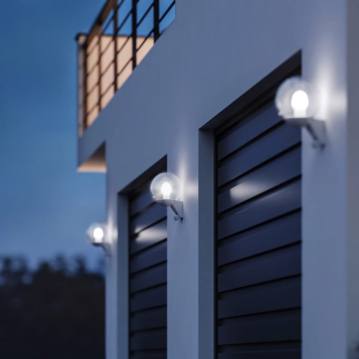 Außenwandleuchten an einem Haus, mit dunklem Himmel im Hintergrund. Drei Lichter sind sichtbar.