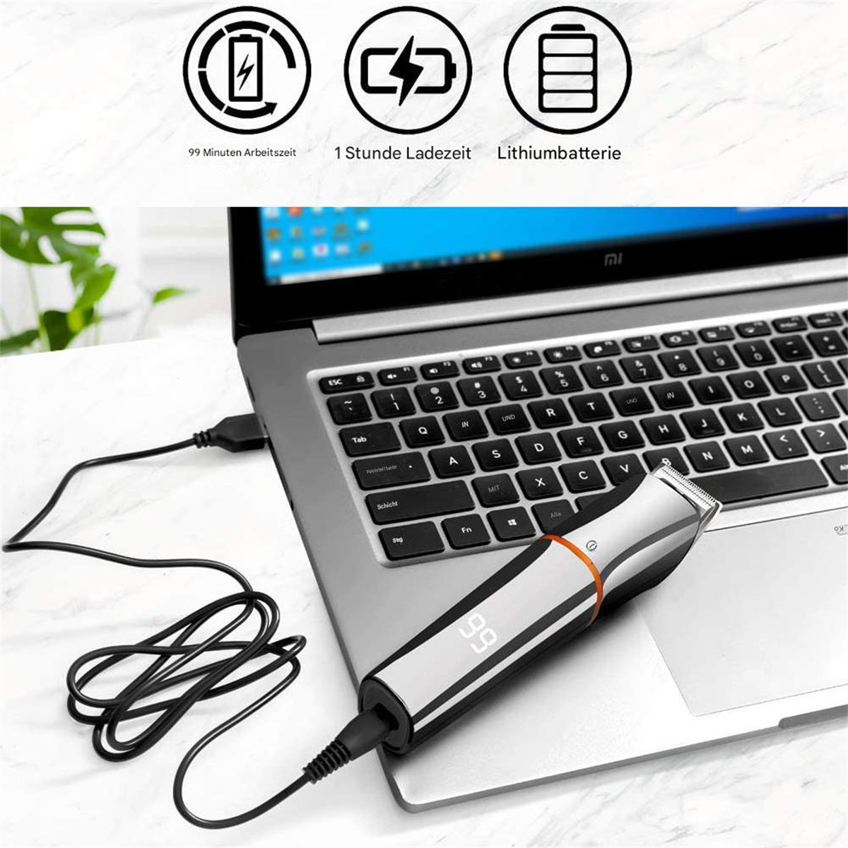 Schwarz-silberner Trimmer auf einem Laptop. Ladekabel eingesteckt, mit Akku- und Ladezeitsymbolen.