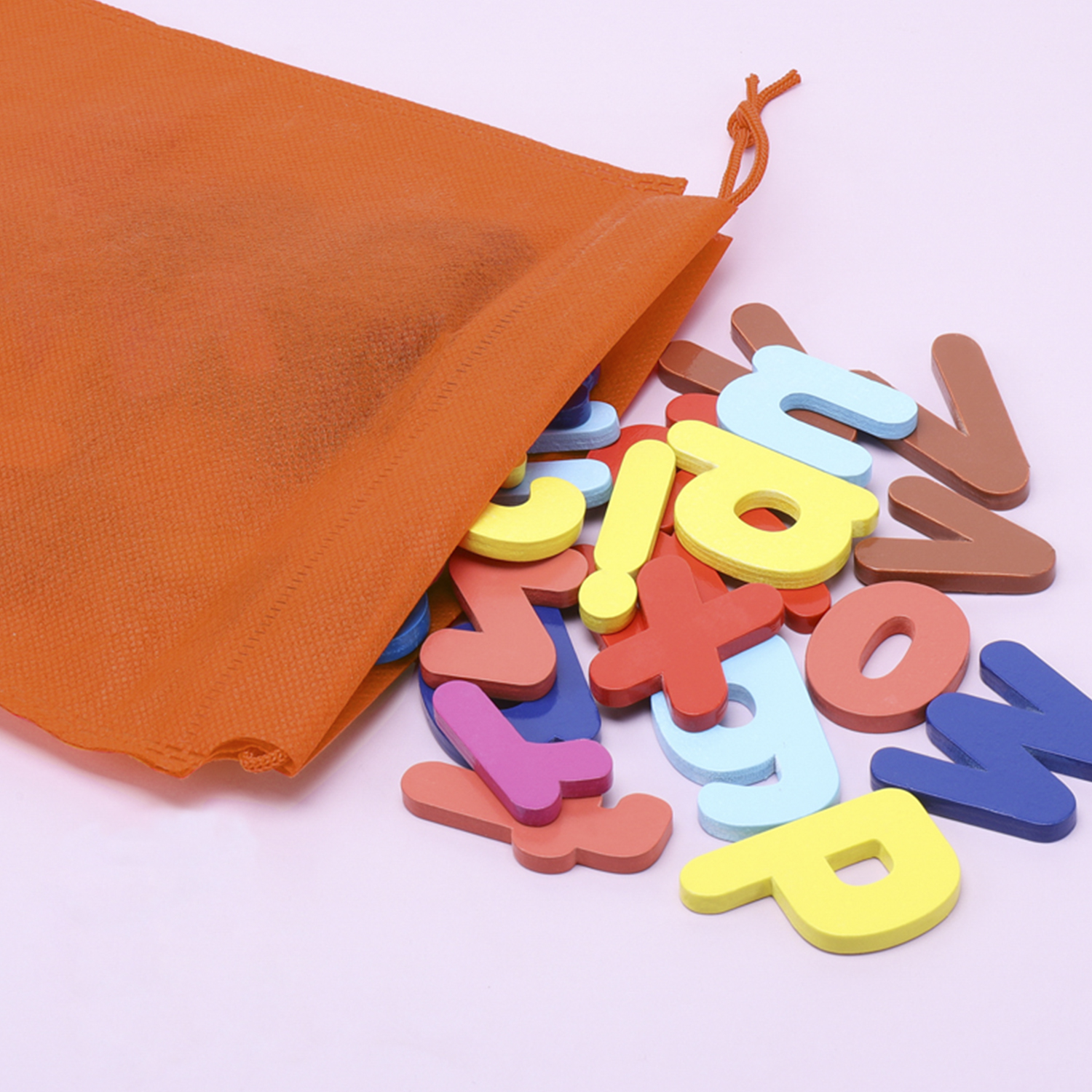Una collezione di lettere di legno colorate che escono da un sacchetto arancione.