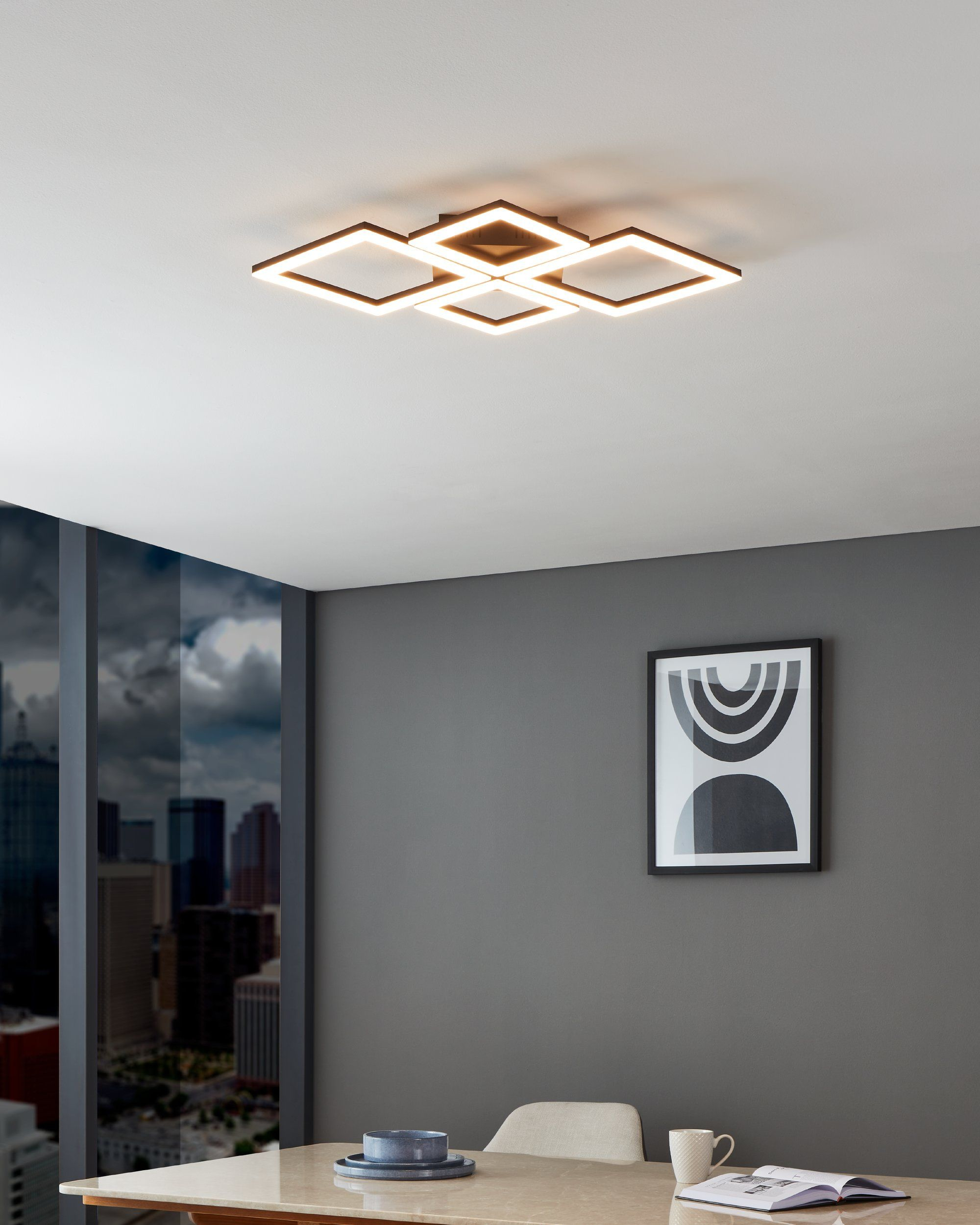Un apparecchio di illuminazione a soffitto con luci quadrate, con una scena d'interni moderna sullo sfondo.