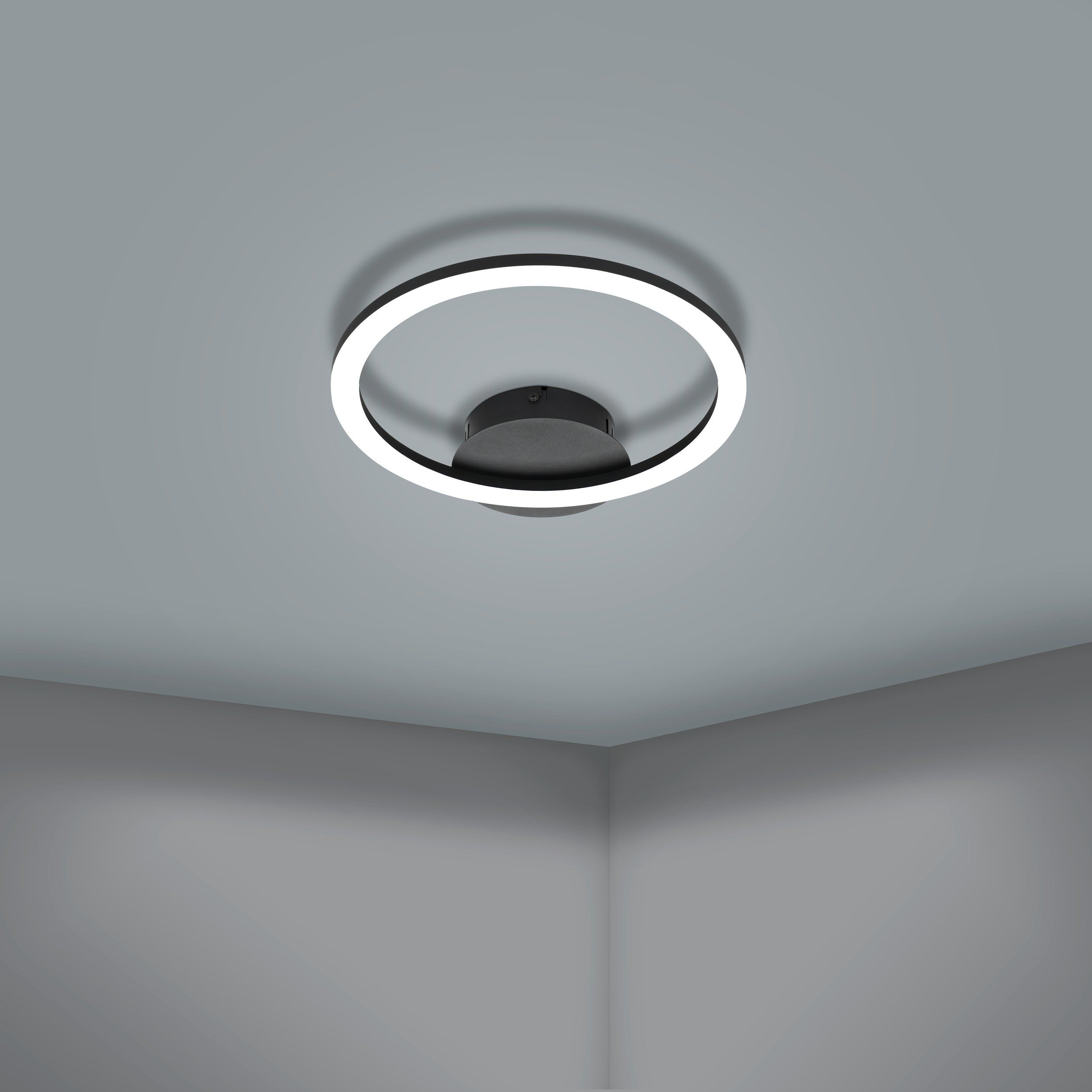 Una plafoniera in bianco e nero con un design circolare e un soffitto grigio scuro.