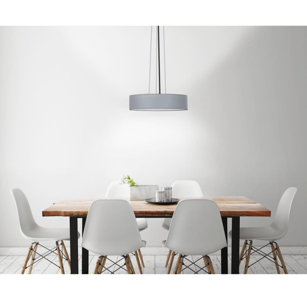 Esszimmer. Holztisch mit weißen Stühlen, graue Lampe.