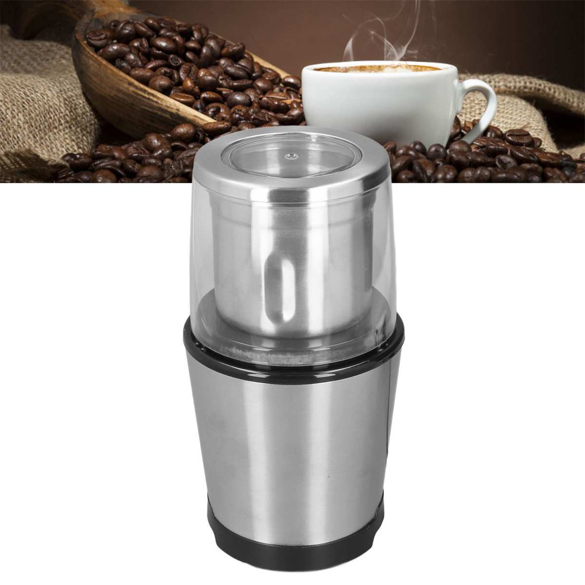 Kaffeemühle mit klarem Deckel und Tasse Kaffee und Bohnen im Hintergrund.