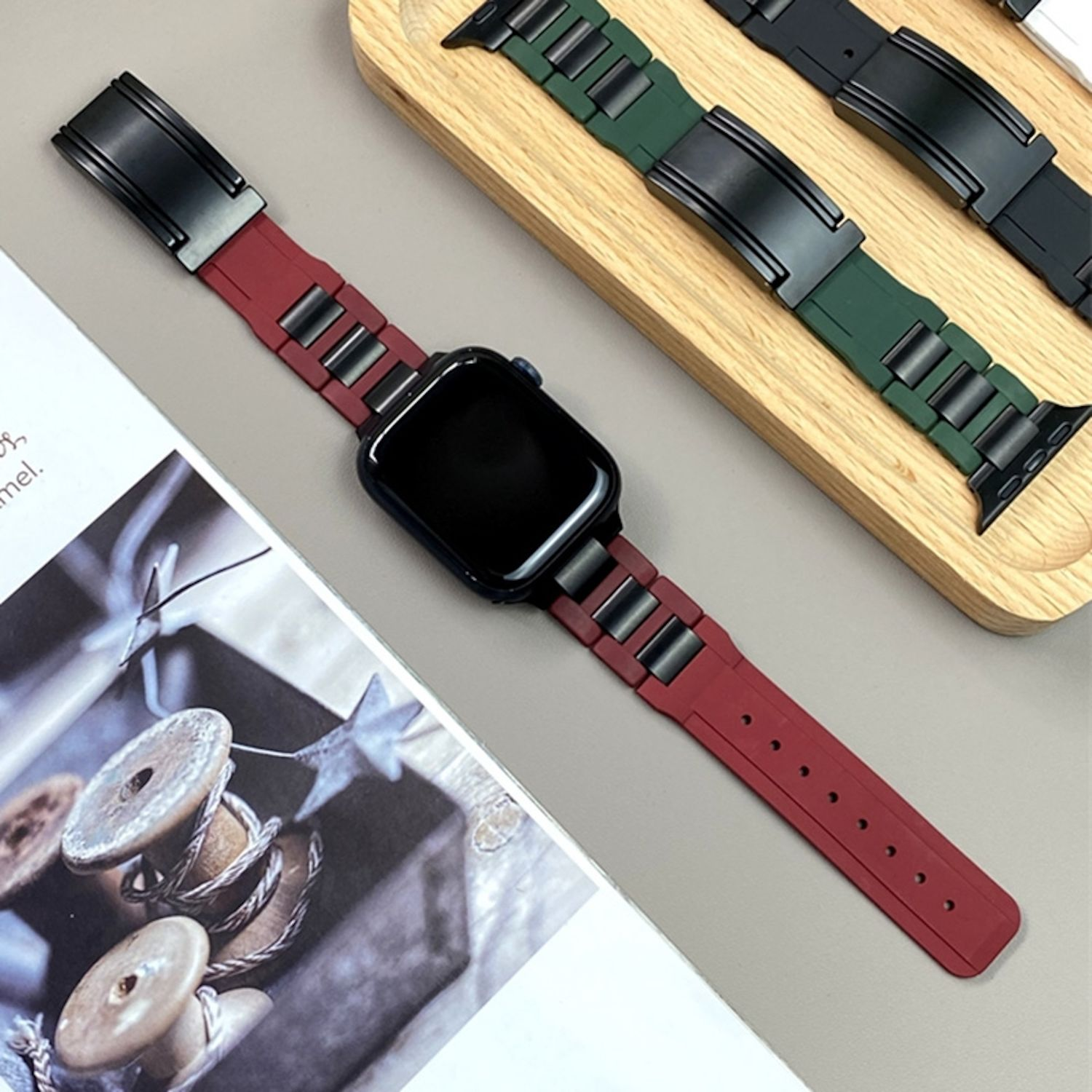 Armbänder: rot, grün und schwarz, mit Uhrenverschluss, auf Holzoberfläche.