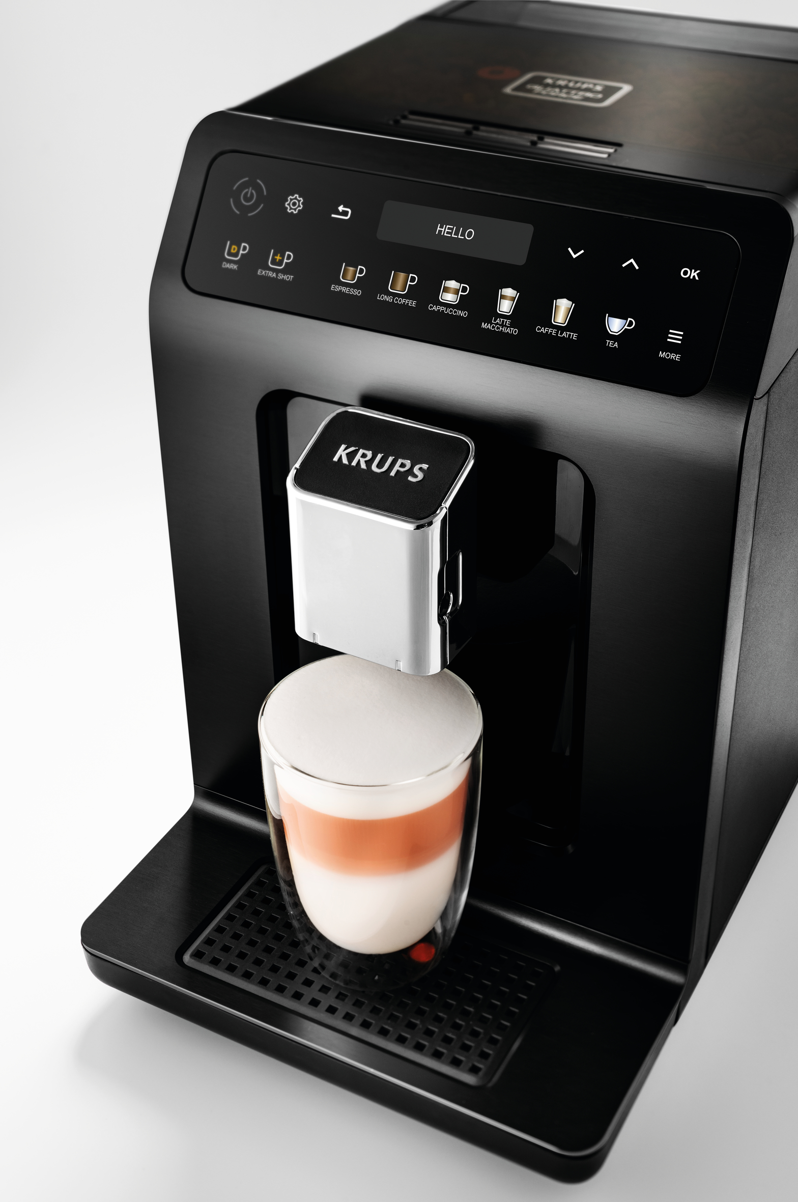 Czarny i srebrny ekspres do kawy dozujący latte do szklanki. Białe tło.