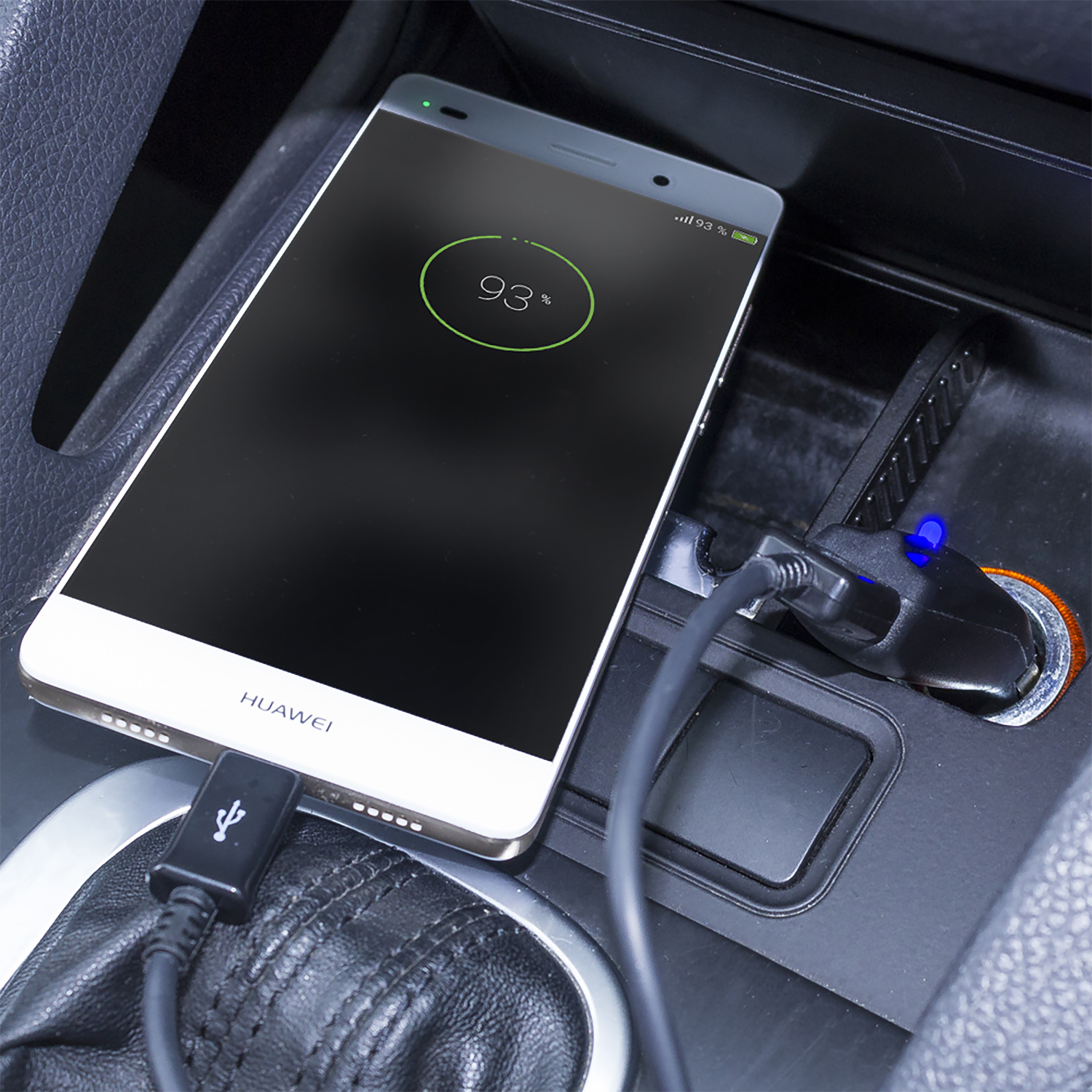 Un telefono Huawei bianco e oro in carica nella porta di ricarica di un'auto.