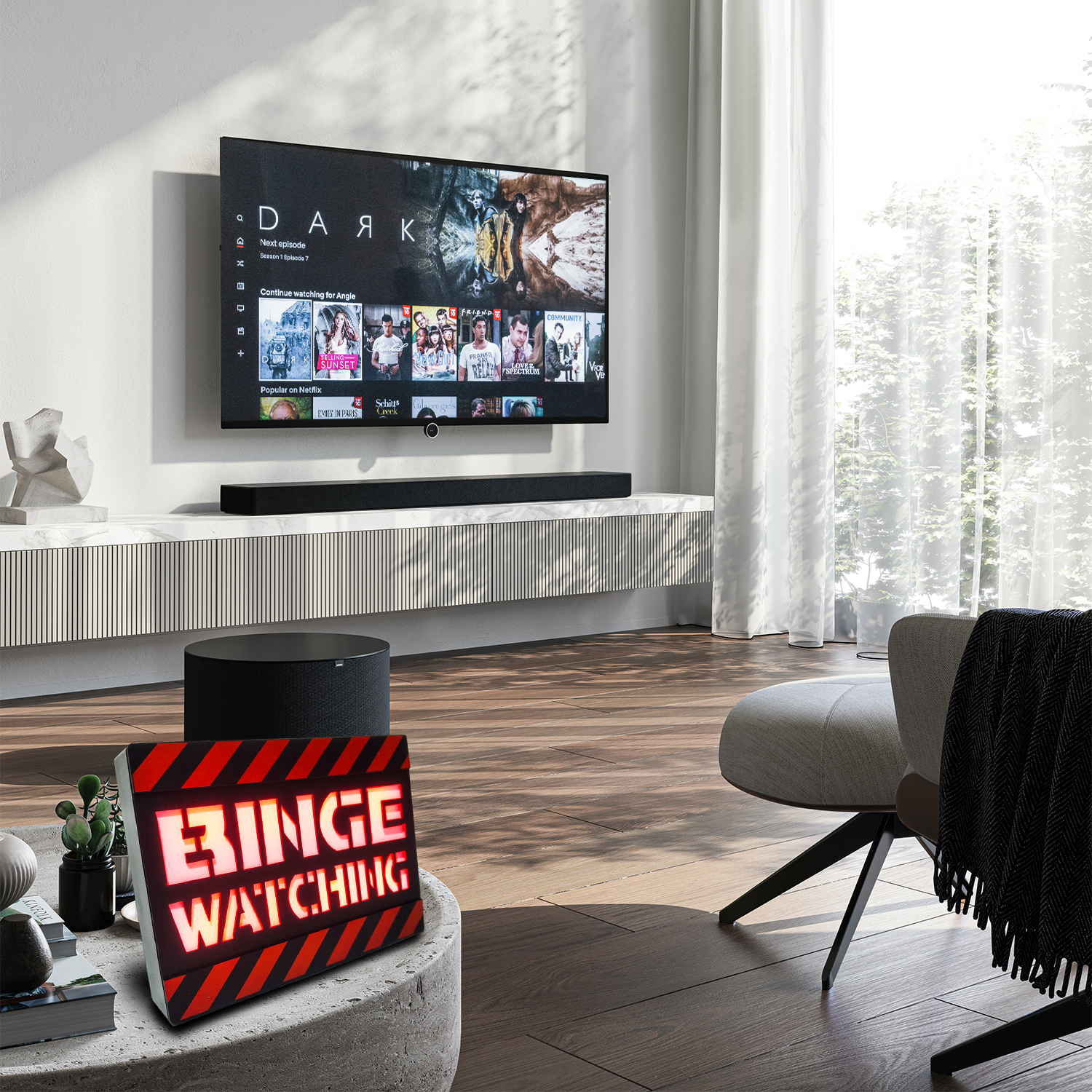 Soggiorno con TV, soundbar e un cartello 'Binge Watching' su un tavolo.