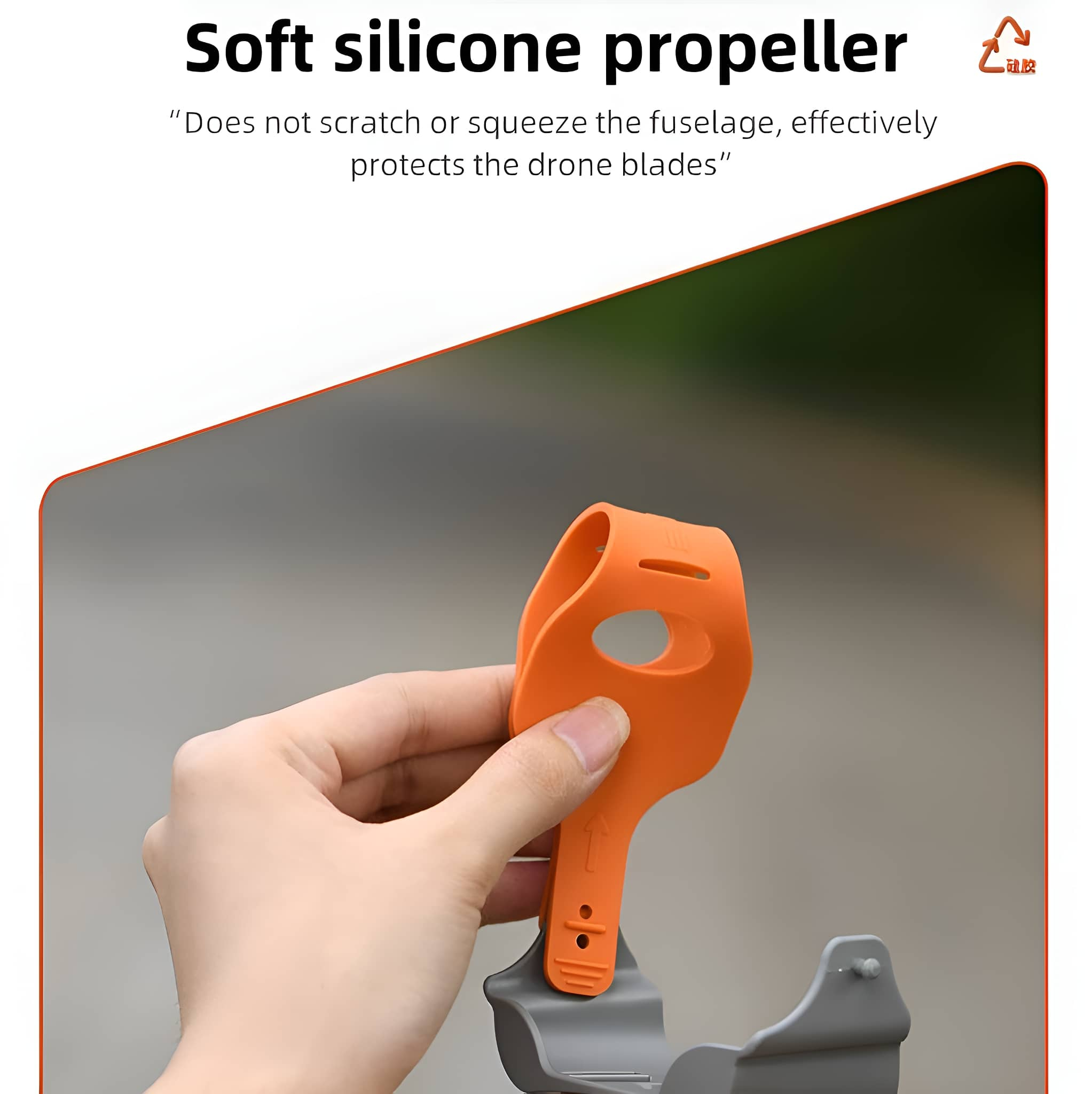 Ein orangefarbener Propeller aus weichem Silikon wird in der Hand gehalten, vor verschwommenem Hintergrund.