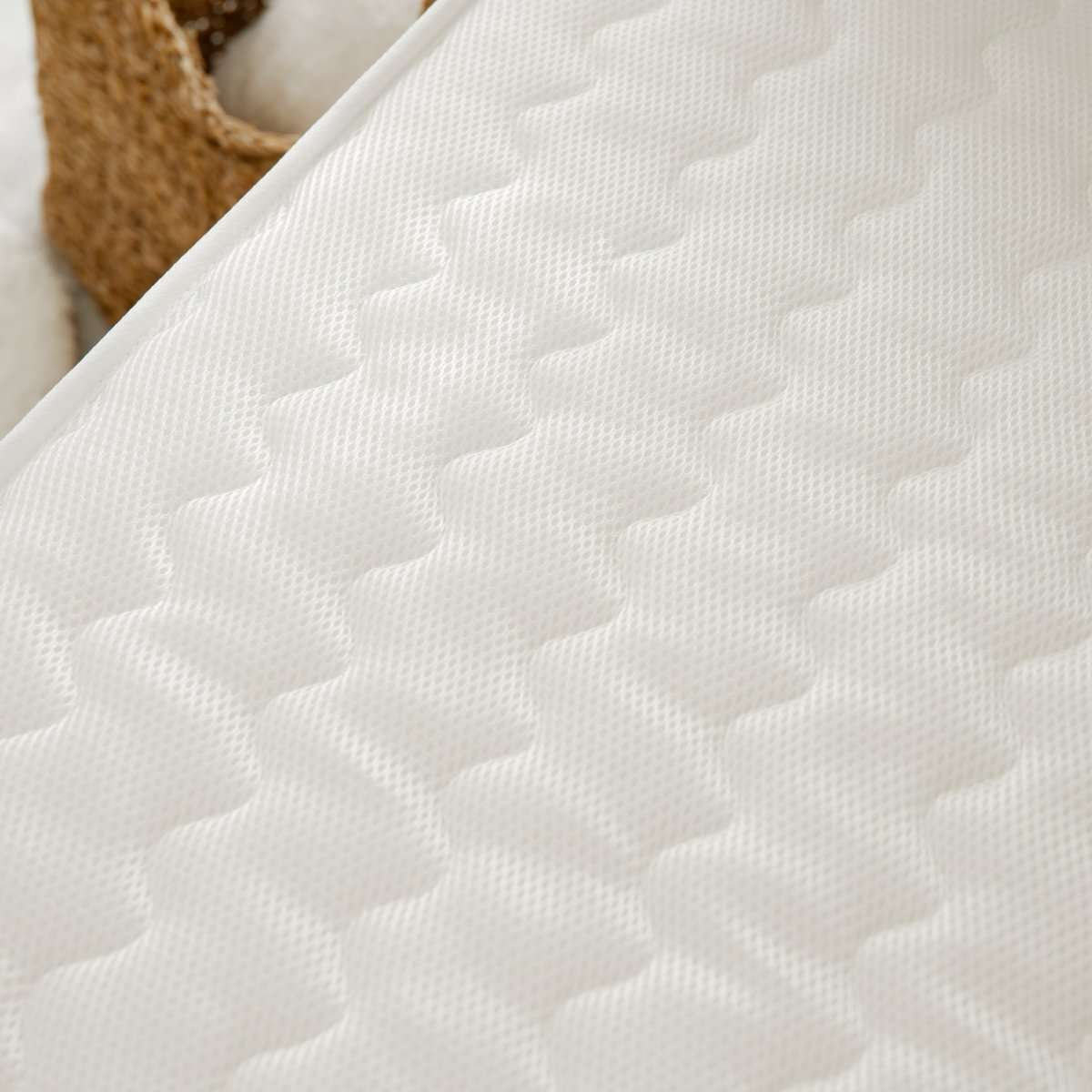 Colchón blanco con un diseño acolchado. El patrón es una serie de formas de diamante conectadas.