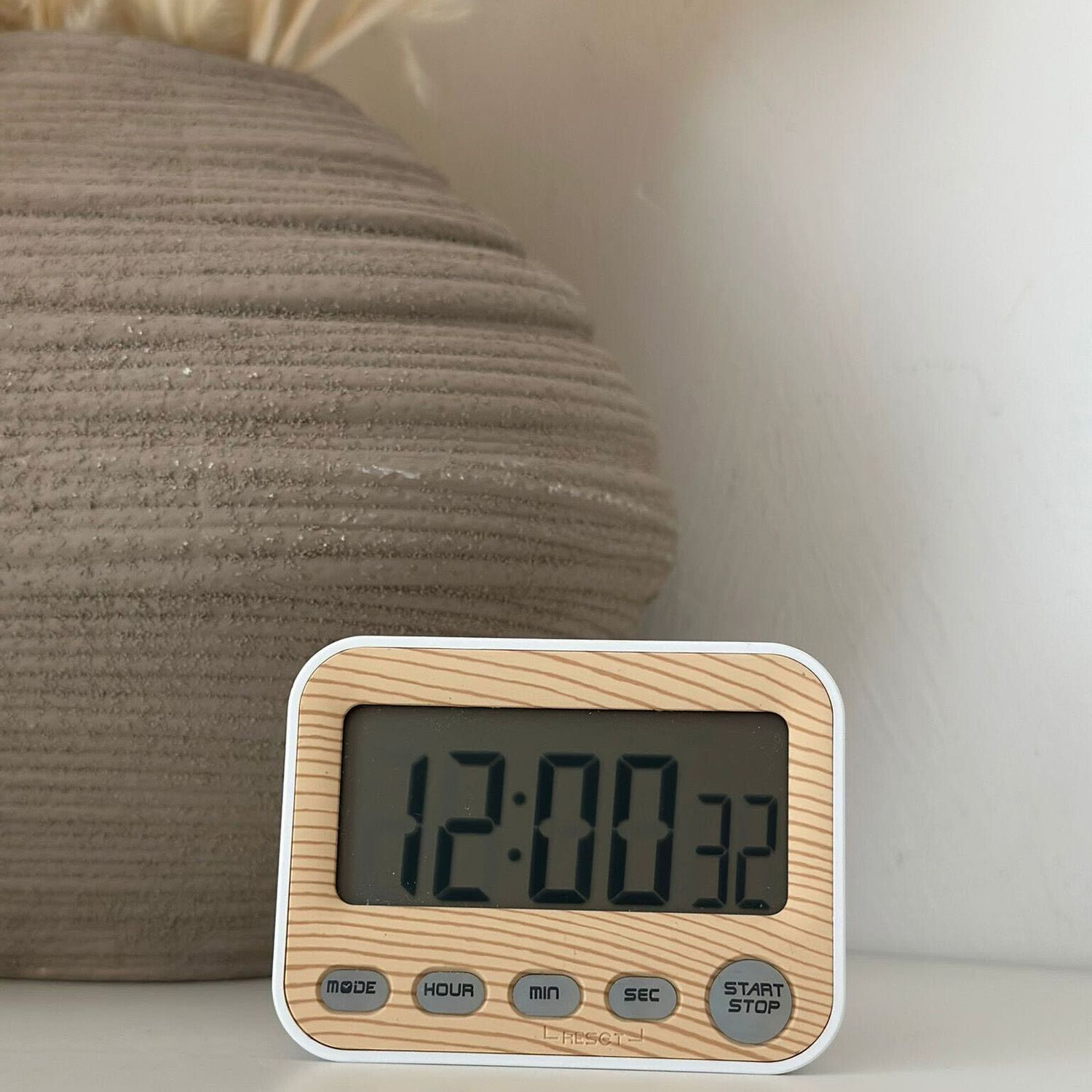 Holztextur-Timer mit Zeitanzeige, auf weißer Oberfläche.
