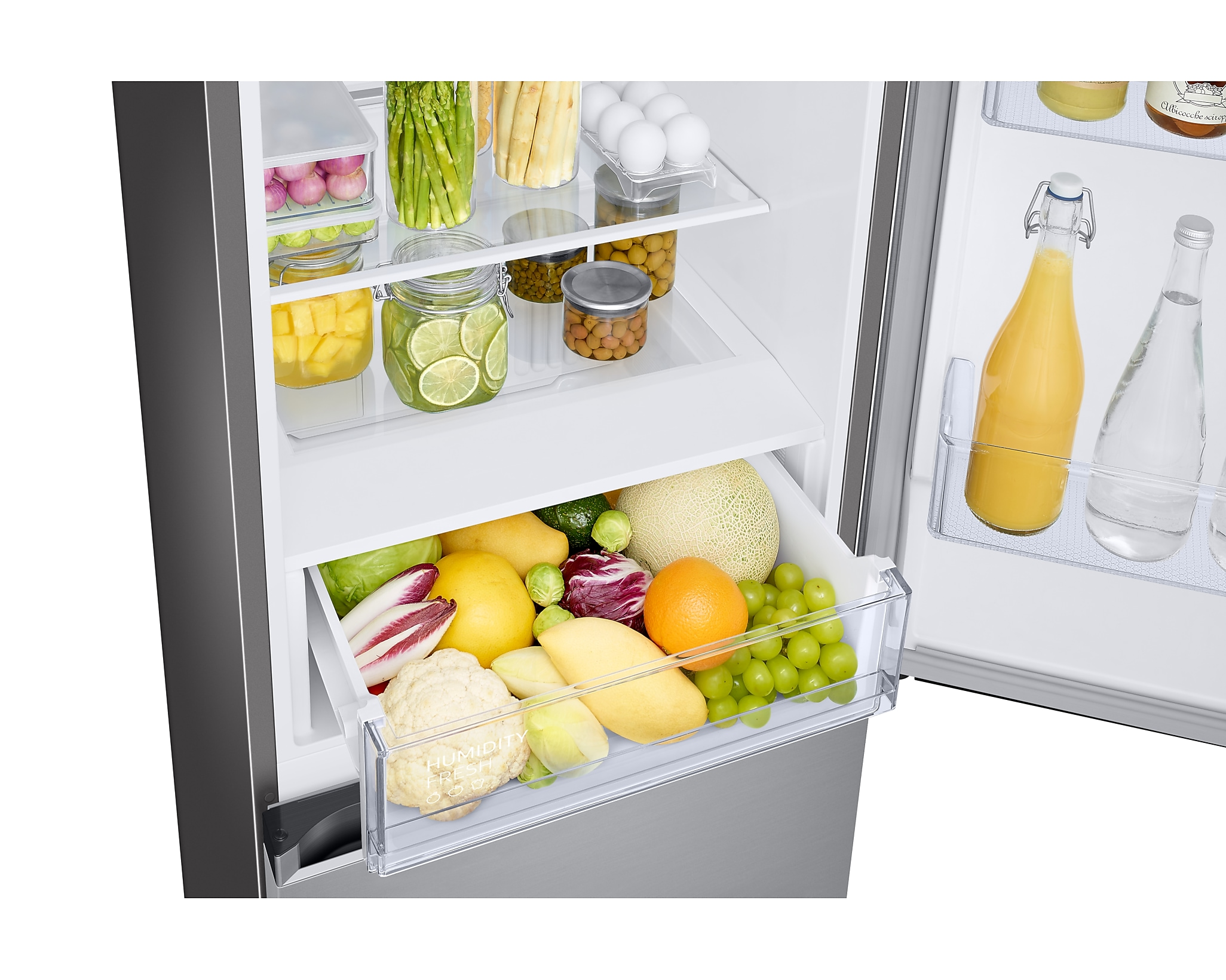 Open refrigerator. Drawers with fruits, vegetables, eggs, and jars. Clear and organized.
