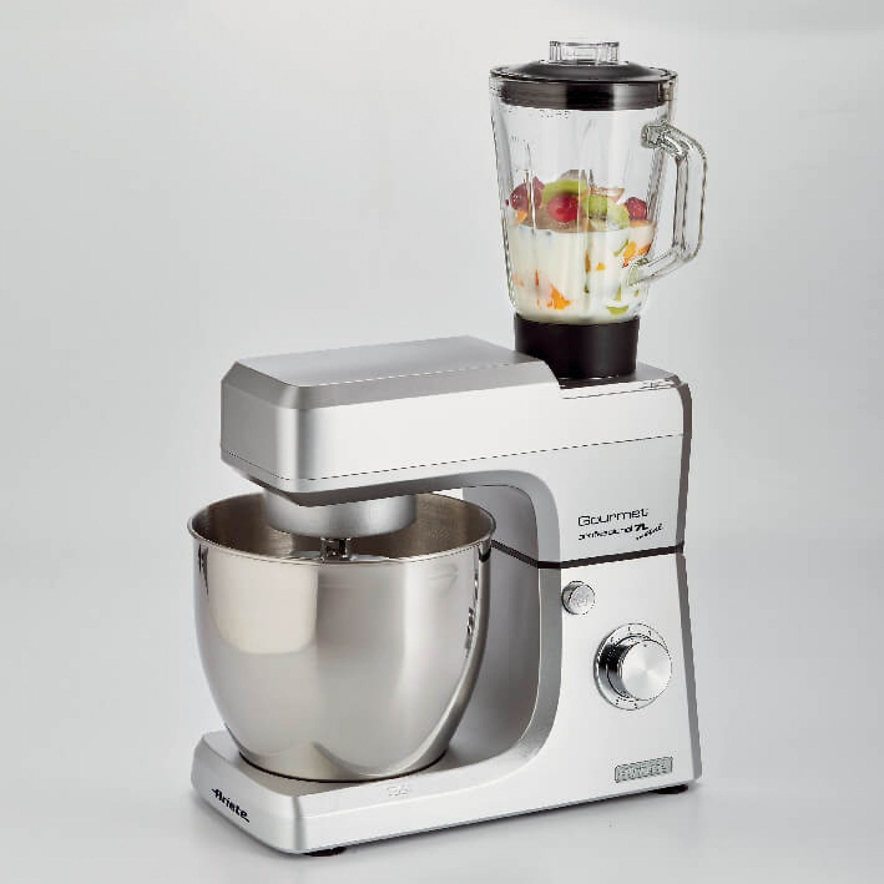 Silberner und grauer Standmixer mit einem Mixeraufsatz. Der Mixer enthält Obst und Flüssigkeit.