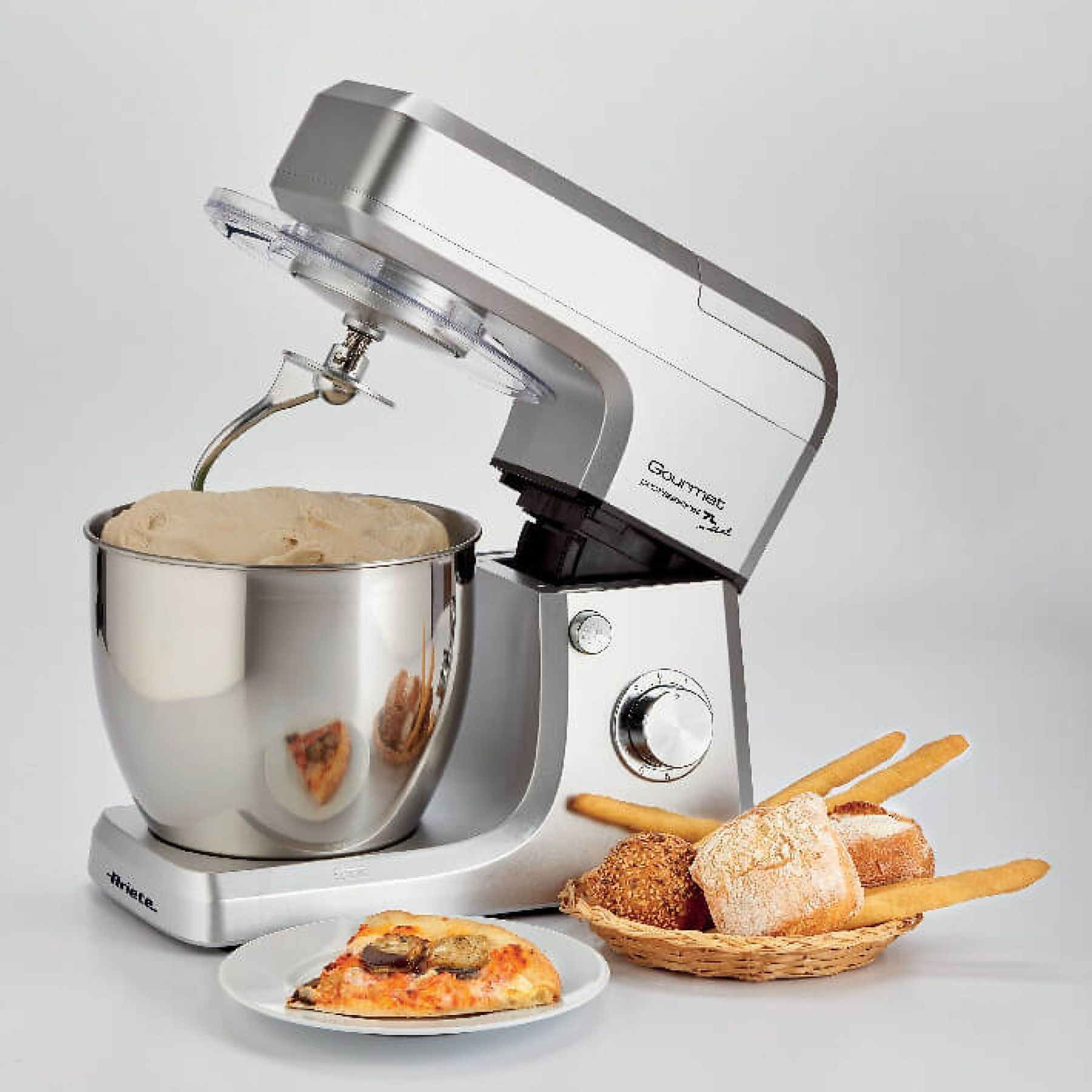 Küchenmixer mit Teig in der Schüssel, Pizza und Brot in einem Korb.