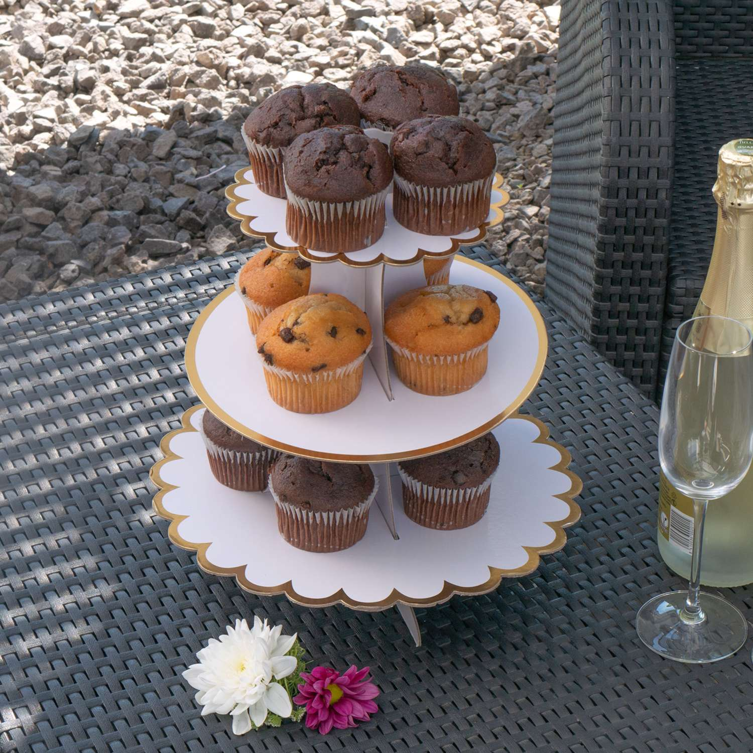 Cupcake-Ständer mit Cupcakes, einer Sektflasche und einem Glas.