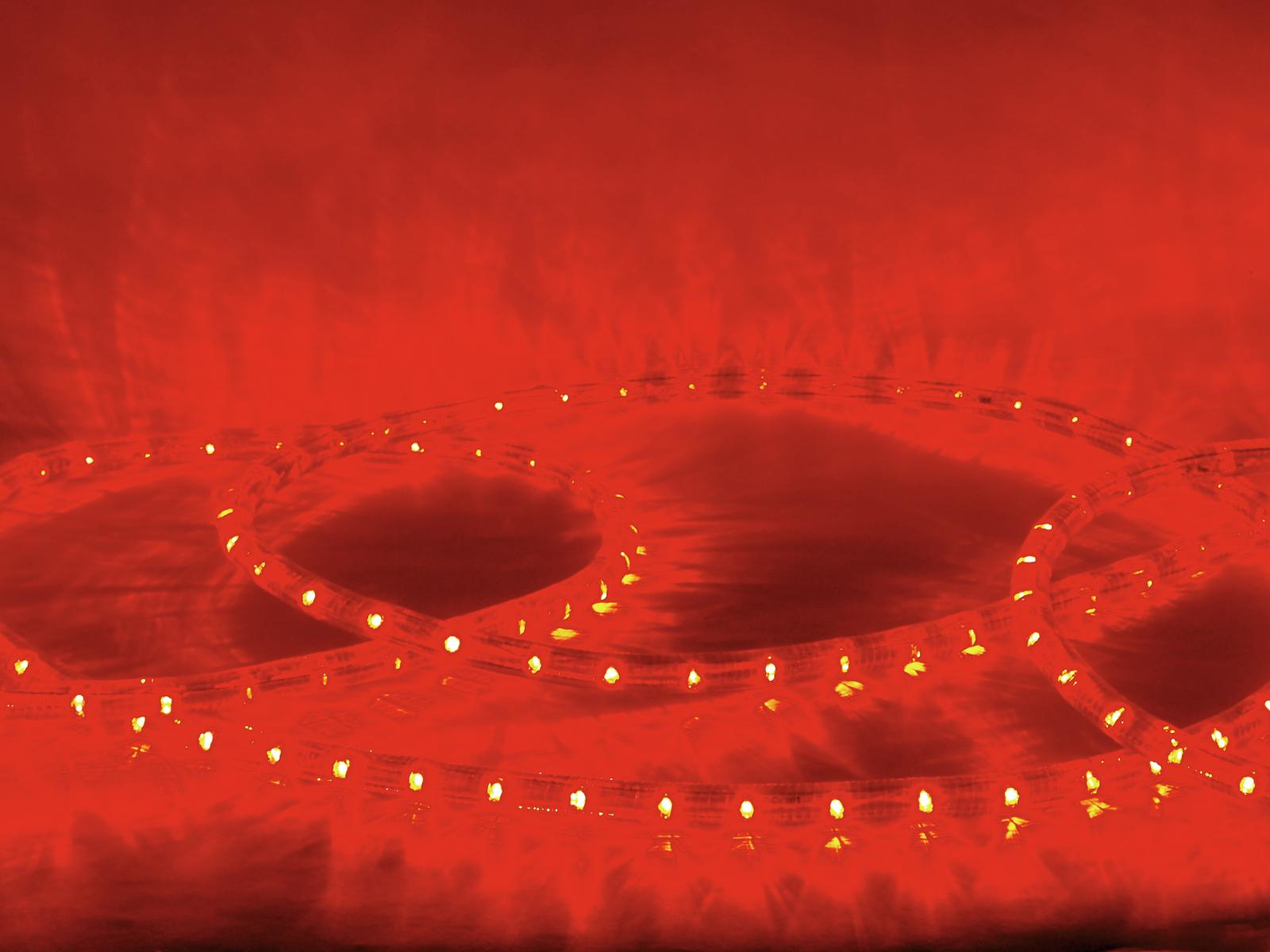 Tiras de luces LED rojas enrolladas sobre fondo rojo.