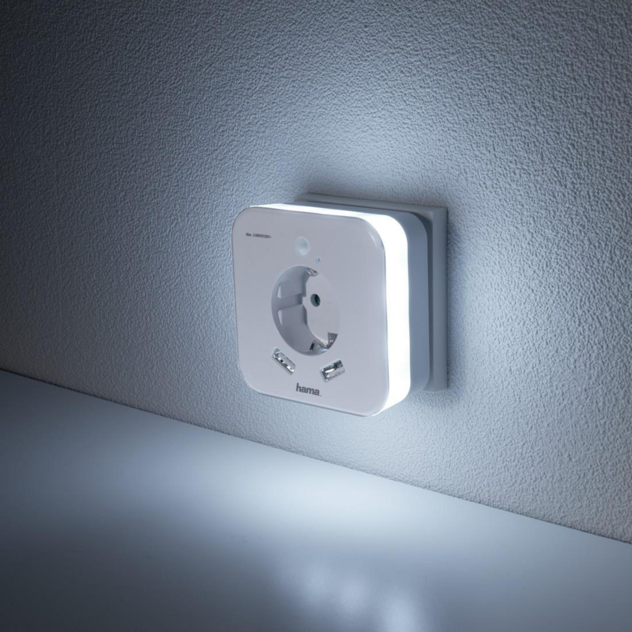 Una luce notturna quadrata bianca collegata a una presa a muro. È illuminata con luce soffusa.