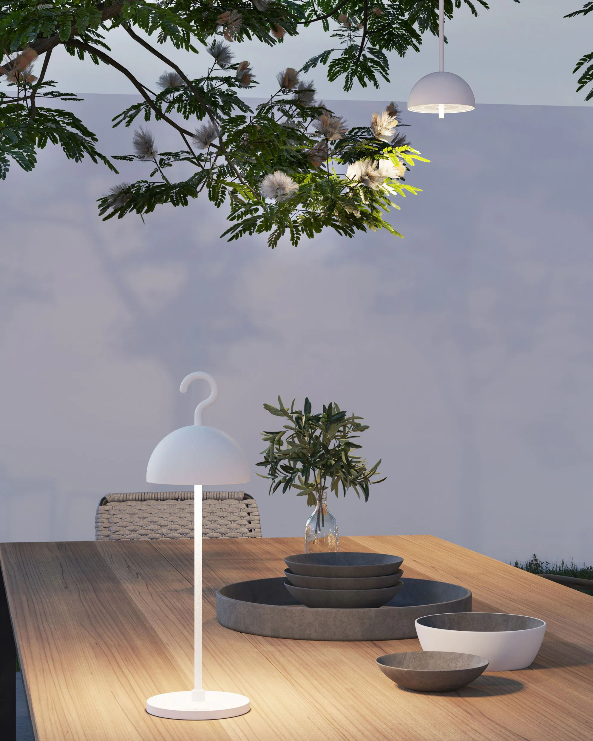 Ustawienie stołu na zewnątrz z lampą, roślinami i wiszącymi światłami.