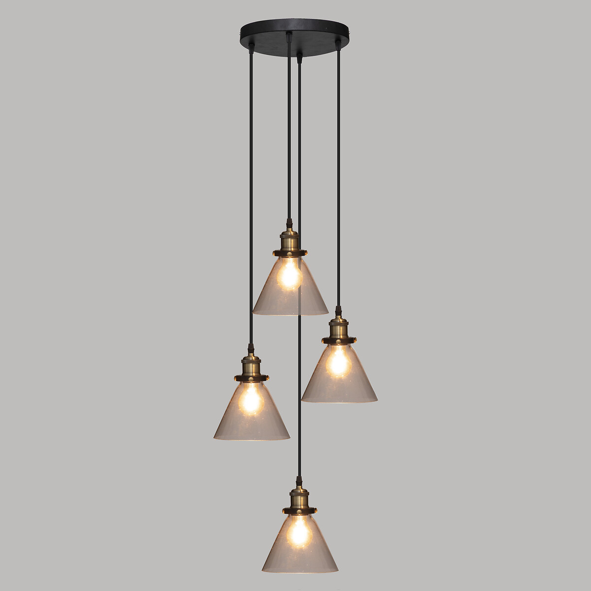 Una lampada a sospensione con 4 luci, con paralumi in vetro trasparente, appesa su sfondo grigio.