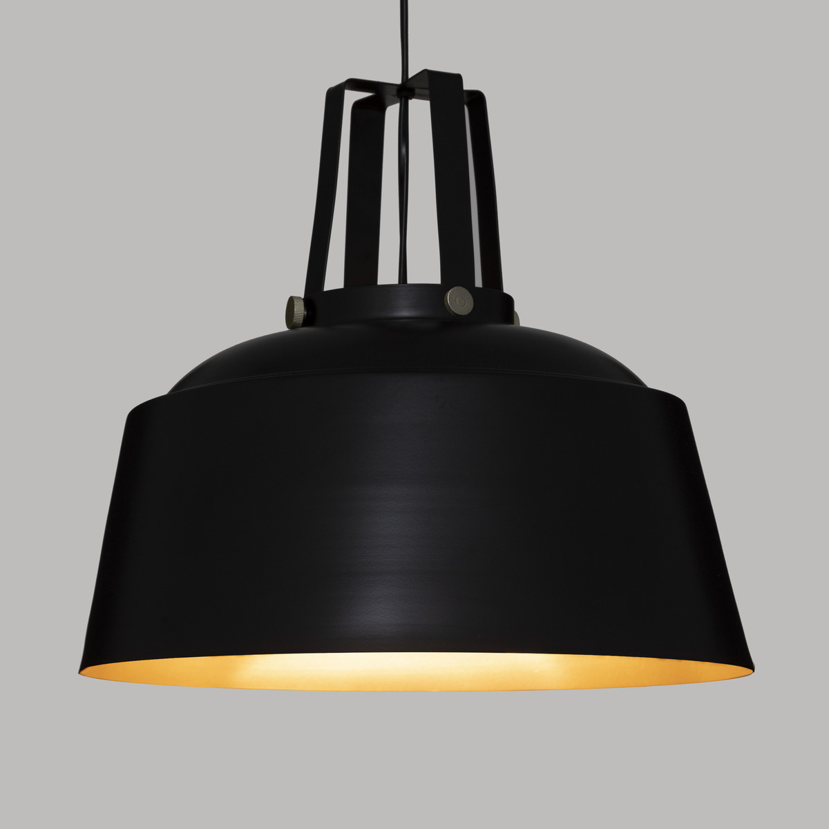 Lampada a sospensione nera a forma conica. L'interno è dorato, su sfondo grigio.