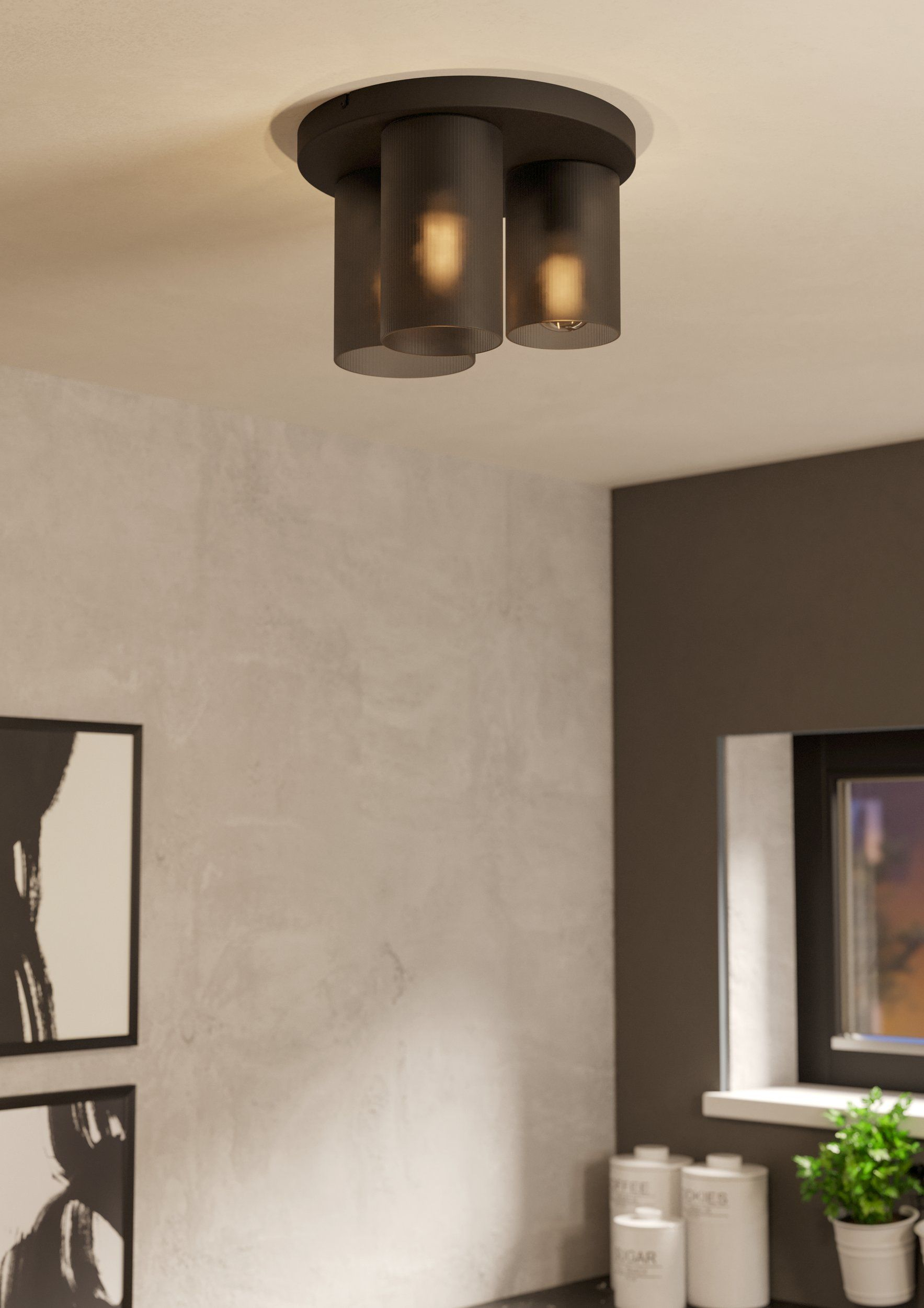 Lampada da soffitto con tre paralumi cilindrici, lampadine visibili, con sfondo neutro.
