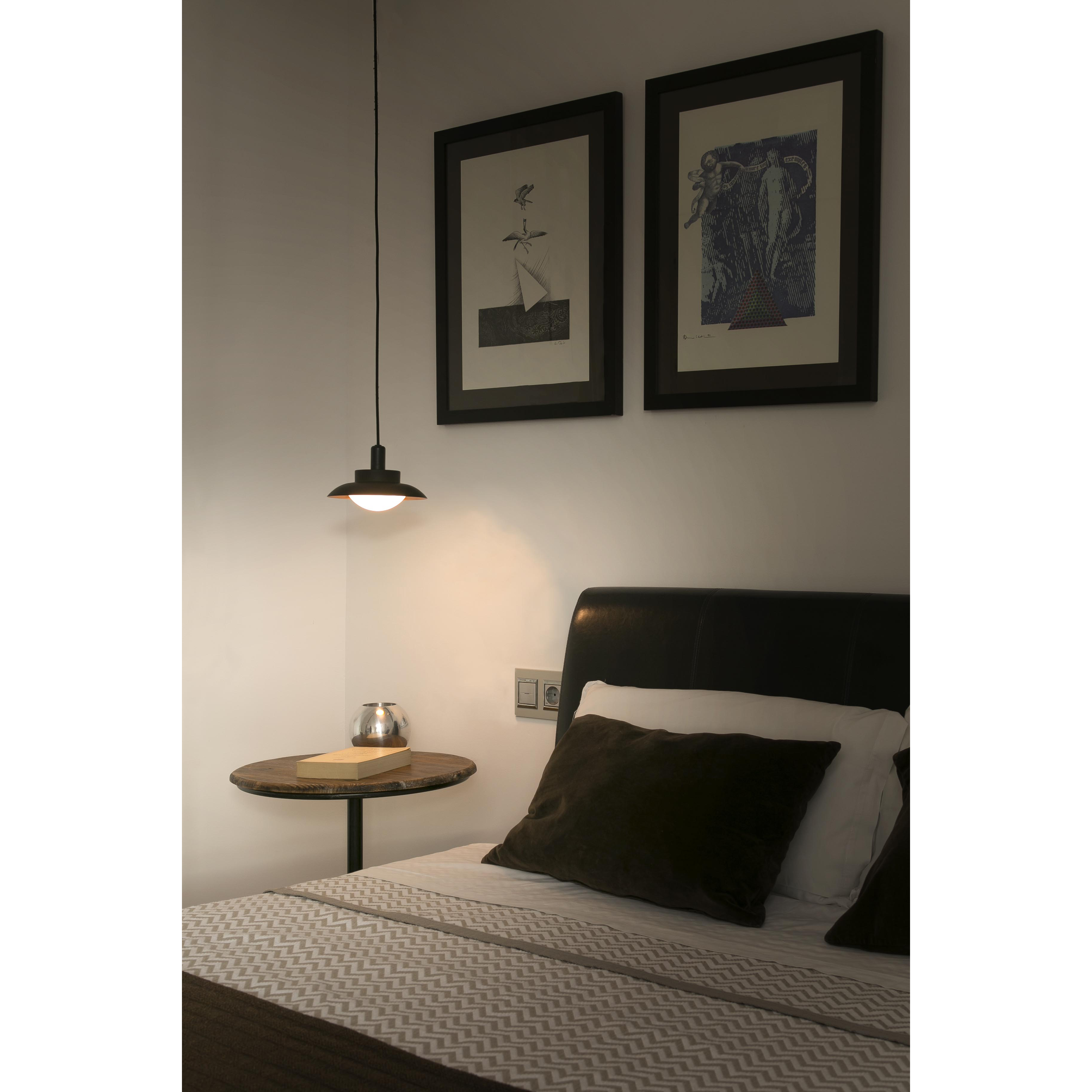 Camera da letto con letto, comodino e lampada a sospensione. Opere d'arte.