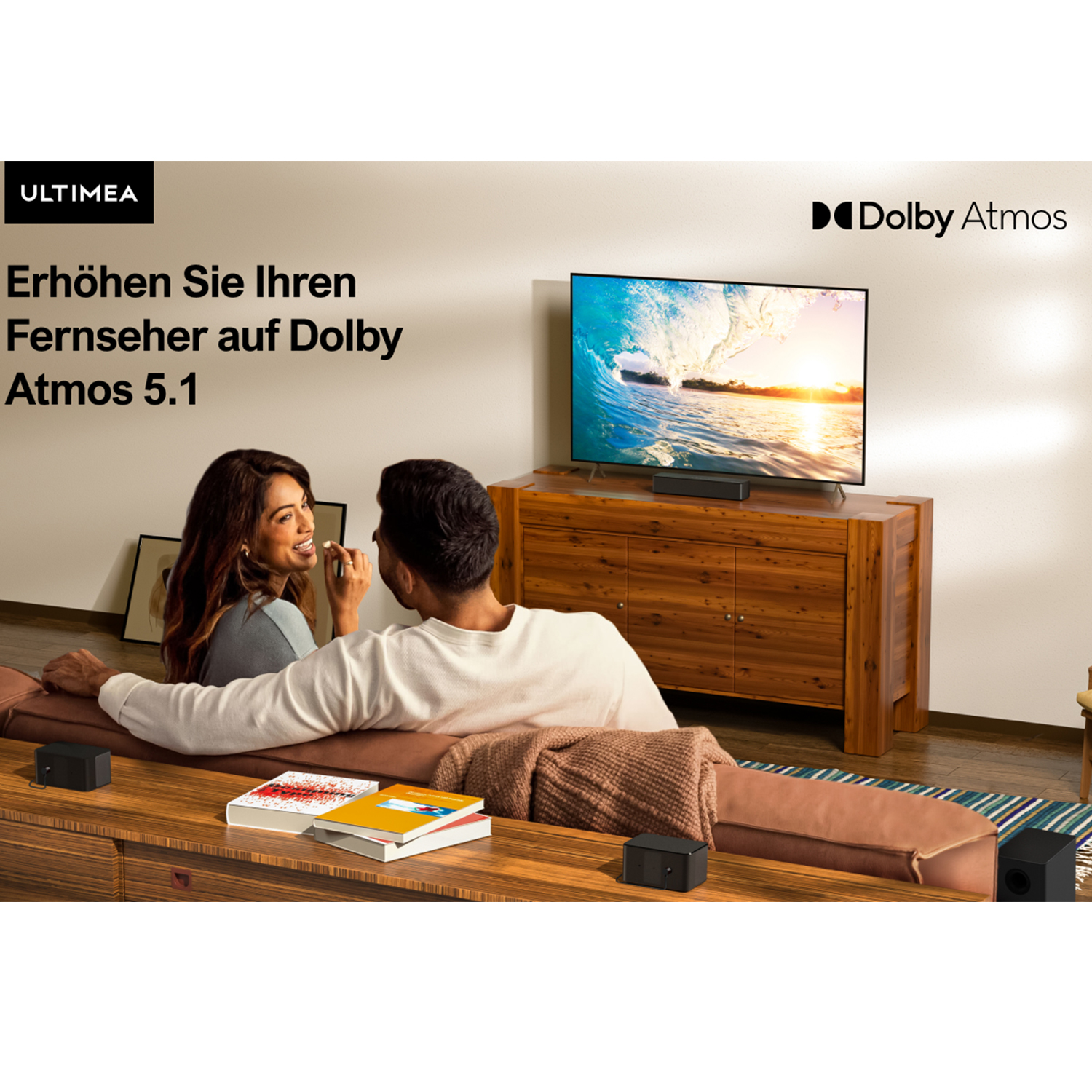 Ein Paar auf einem Sofa schaut fern. Der Fernseher zeigt ein Dolby Atmos Logo.