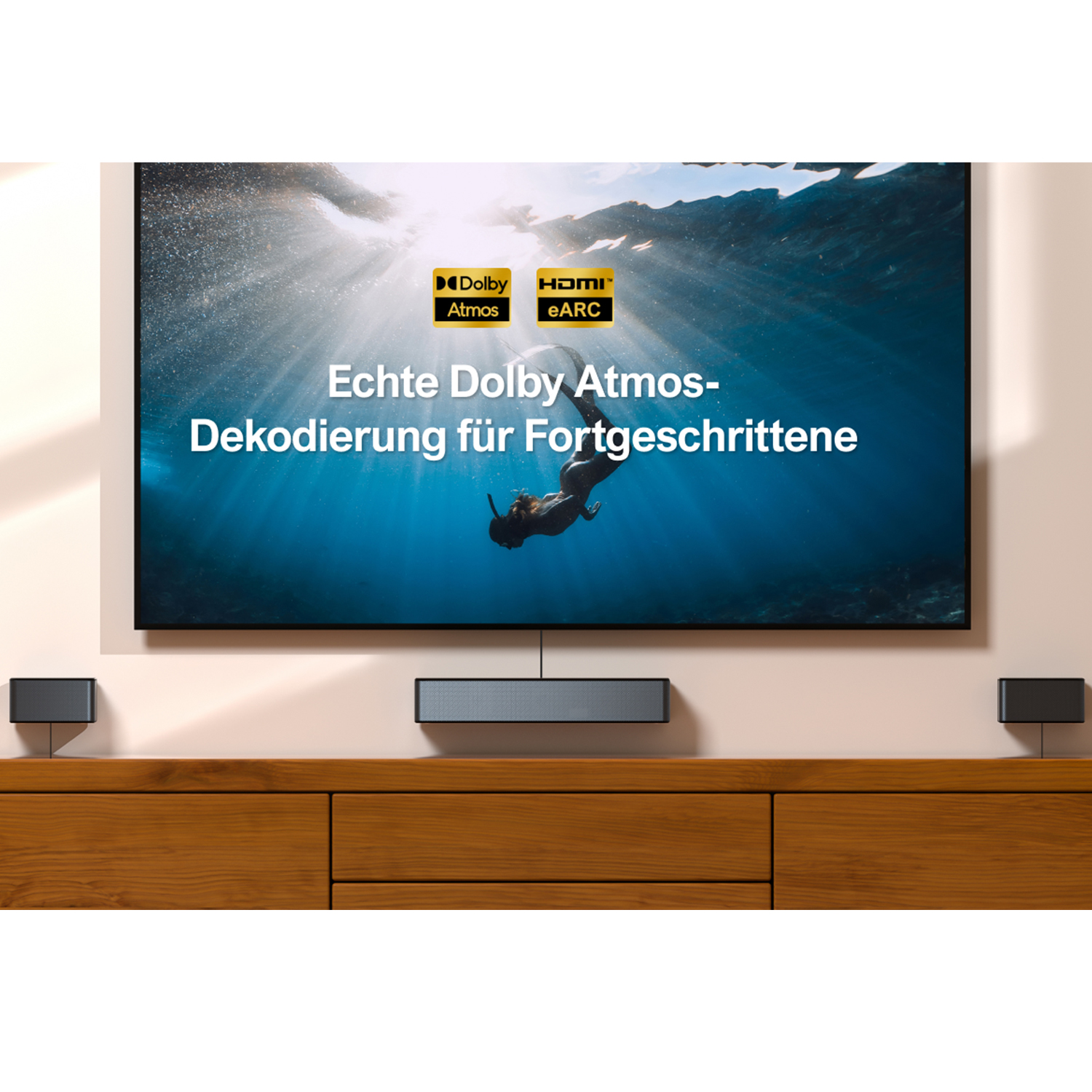 Ekran telewizora z tekstem 'Echte Dolby Atmos-Dekodierung für Fortgeschrittene' pośrodku.