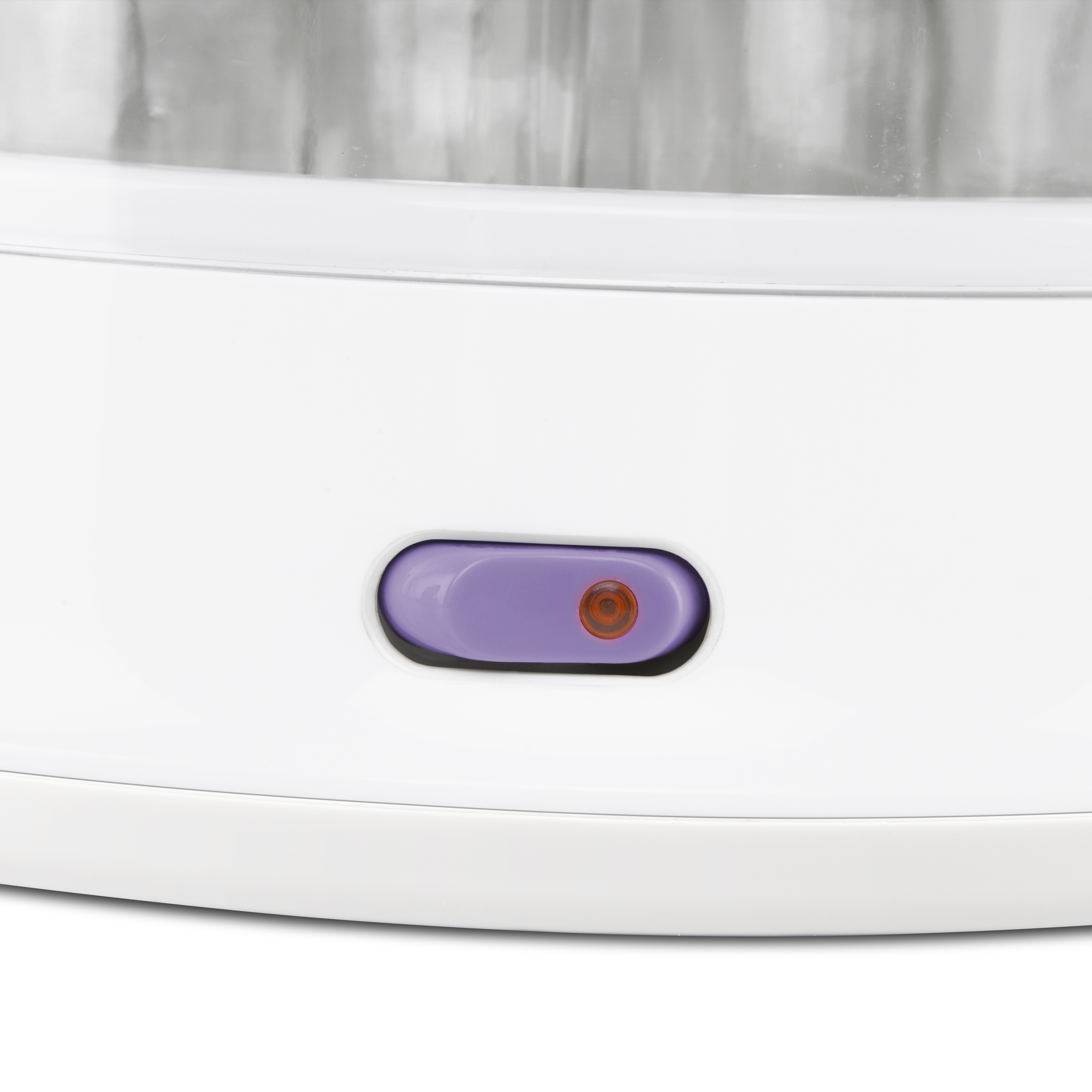 Primer plano de un dispositivo blanco con botón morado y luz indicadora roja.