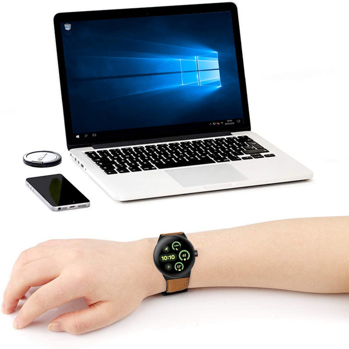 Laptop, telefon i zegarek na stole z ręką osoby.