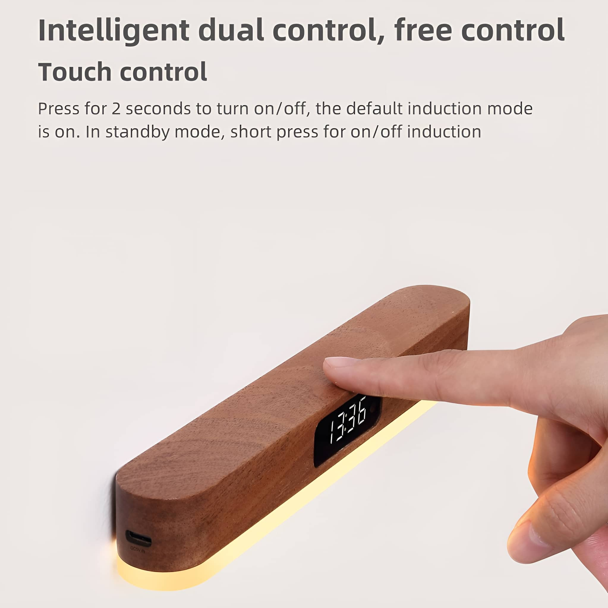 Die Hand einer Person berührt ein Holzgerät mit Digitaluhr. Es liegt auf einer weißen Oberfläche.