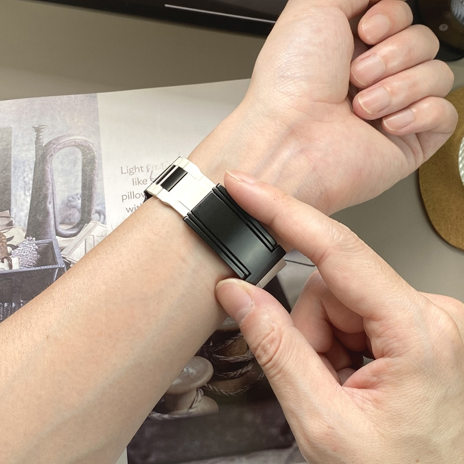 Eine Person, die eine Uhr mit einem schwarz-silbernen Armband trägt.