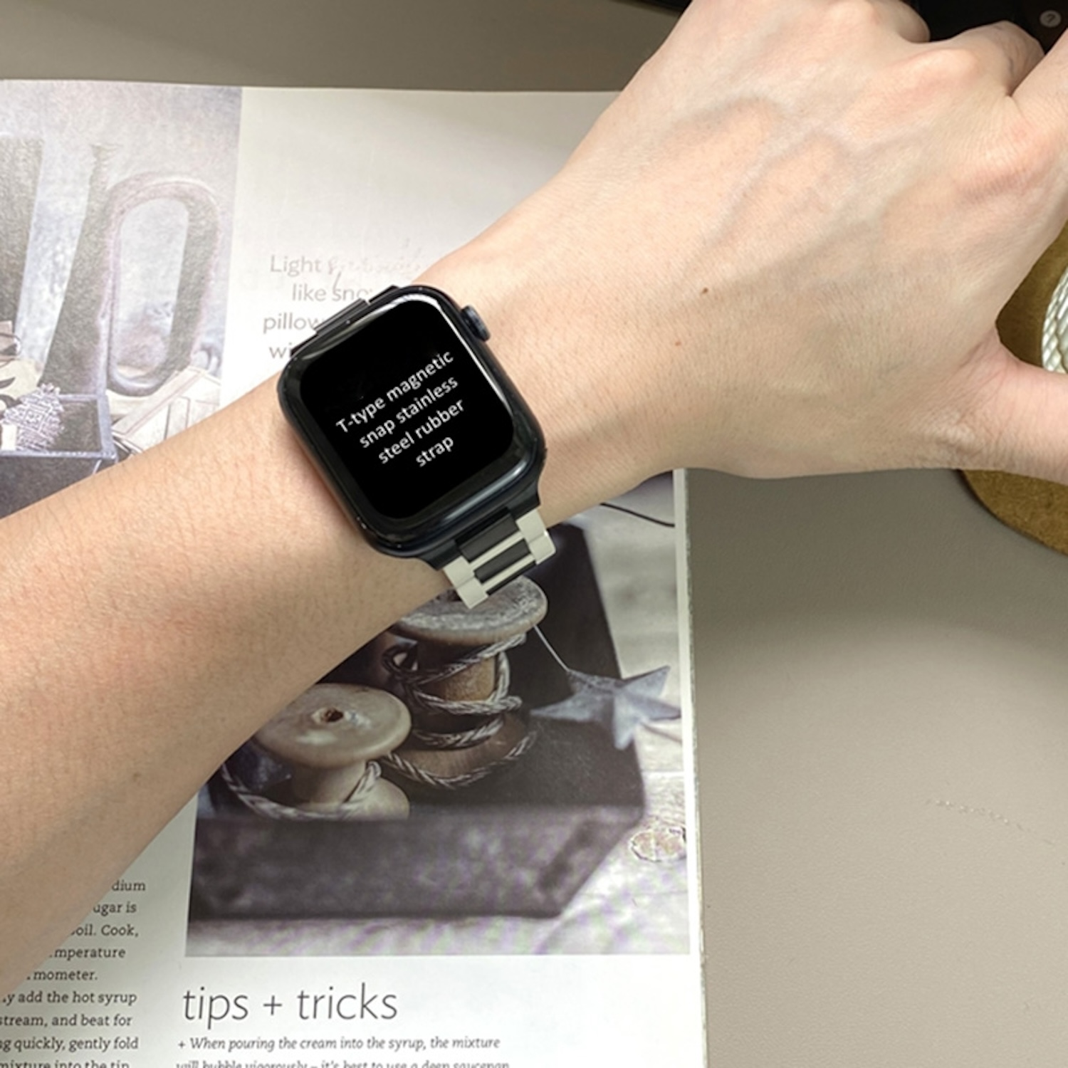 Ein Handgelenk mit Smartwatch, die Text anzeigt. Die Uhr hat ein Metall- und schwarzes Armband.
